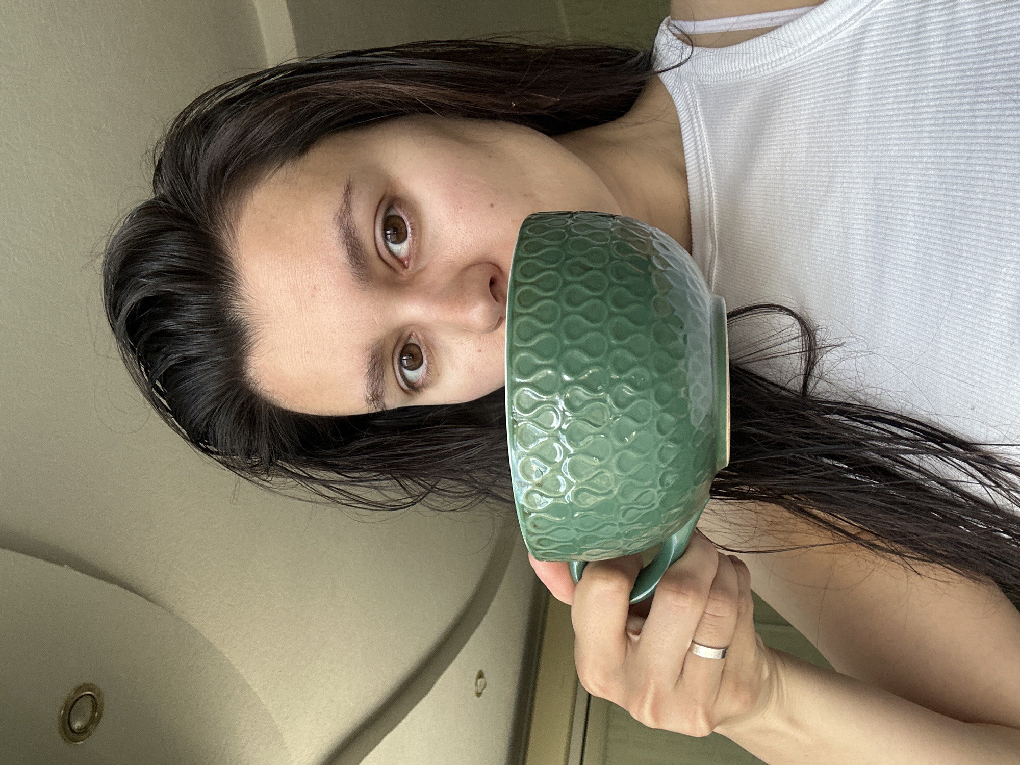 Woman drinks from green mug in early morning Chaikovsky