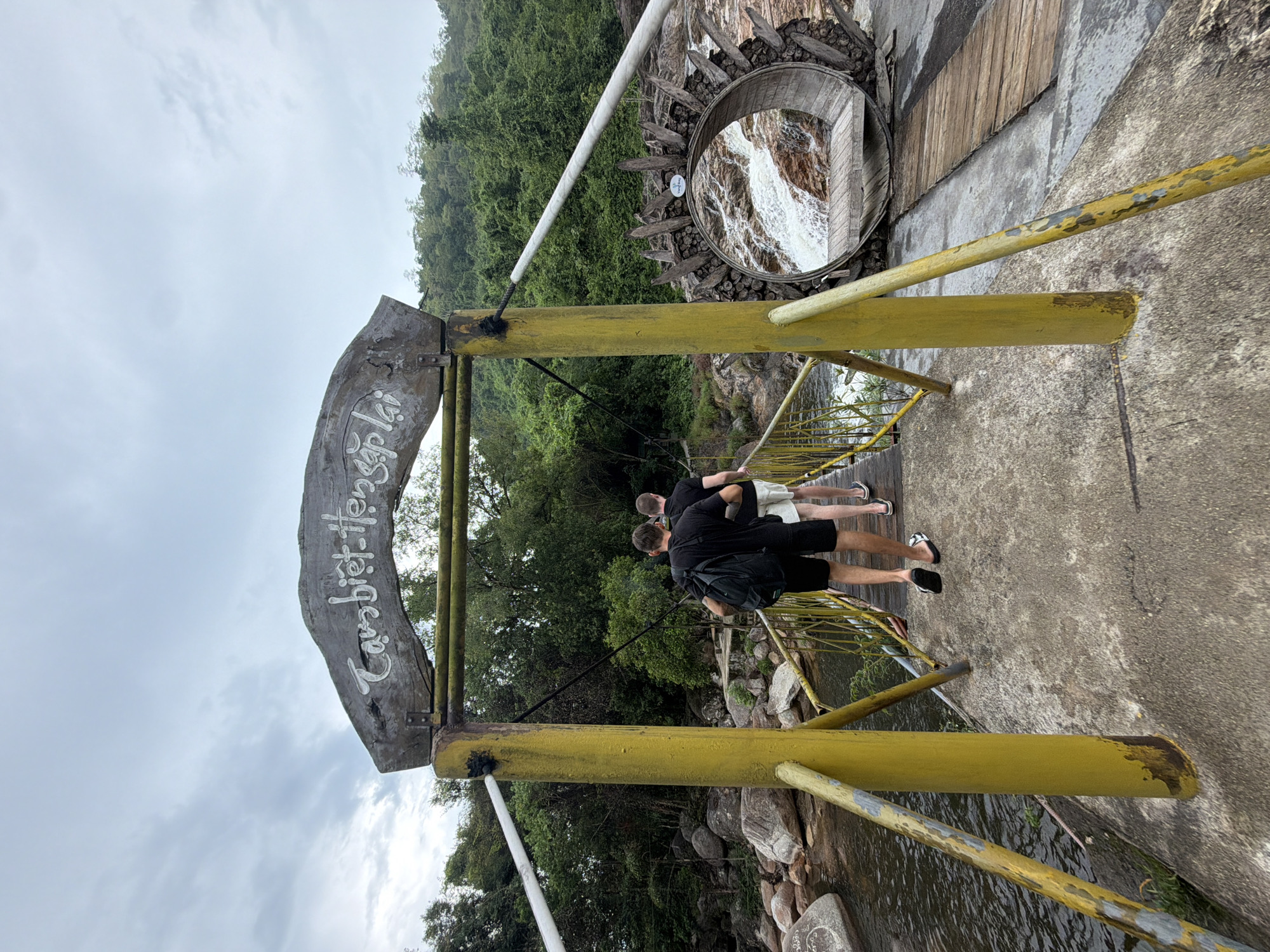 Two men explore Yang Bay Waterfall Park in Vietnam