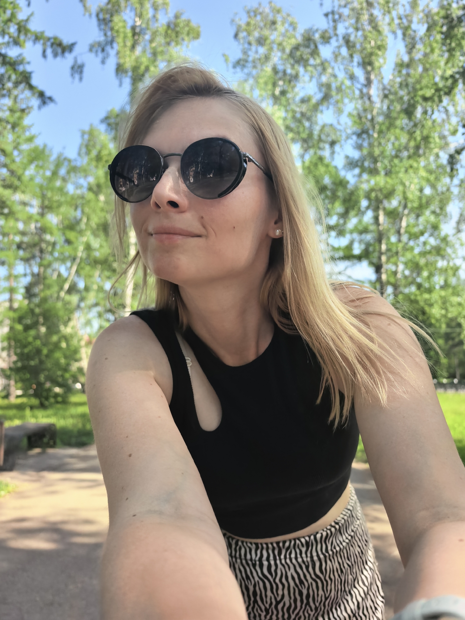 Woman takes selfies, boy with stroller in Sterlitamak park