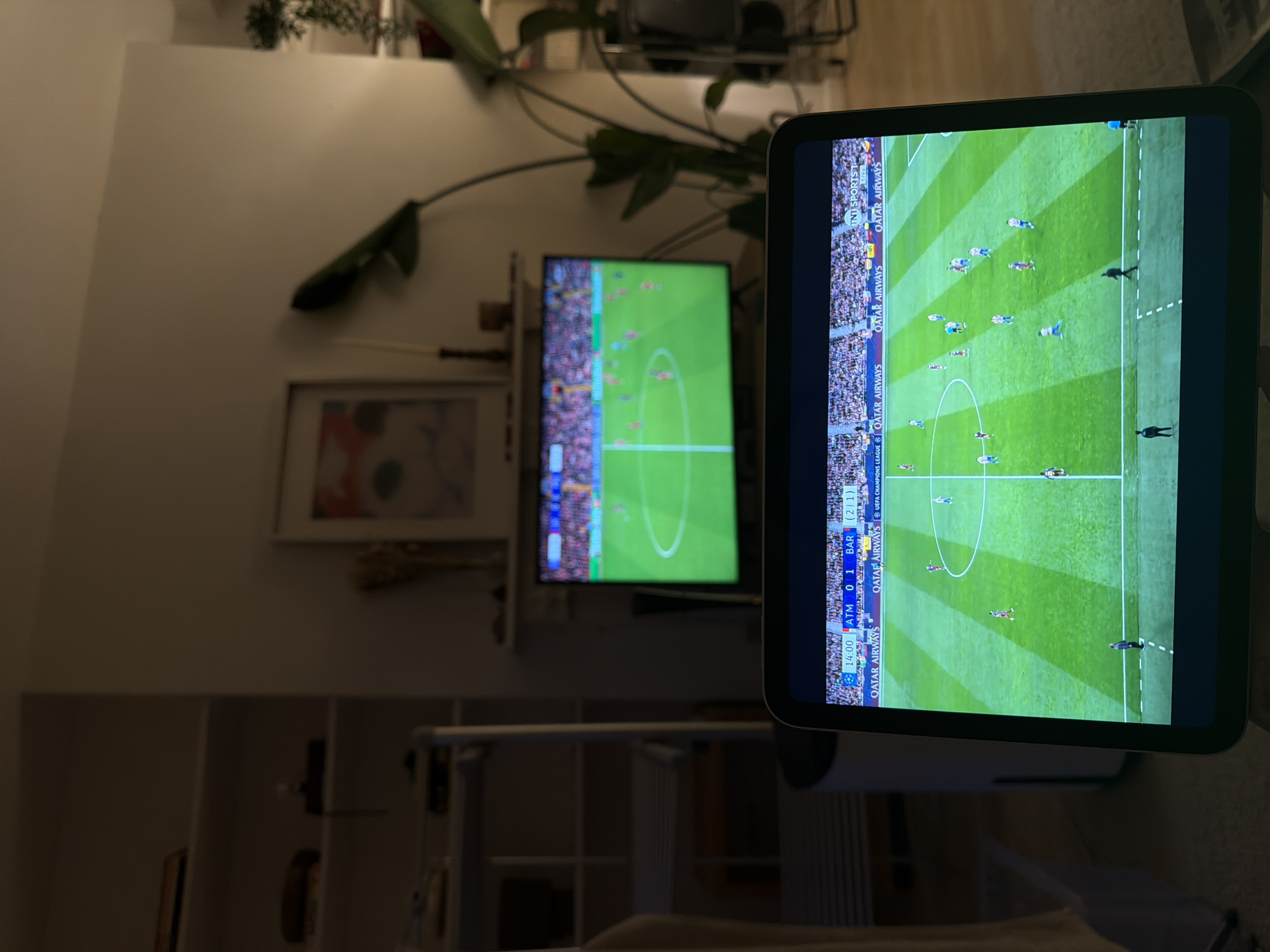 Person watches football match on multiple screens in London