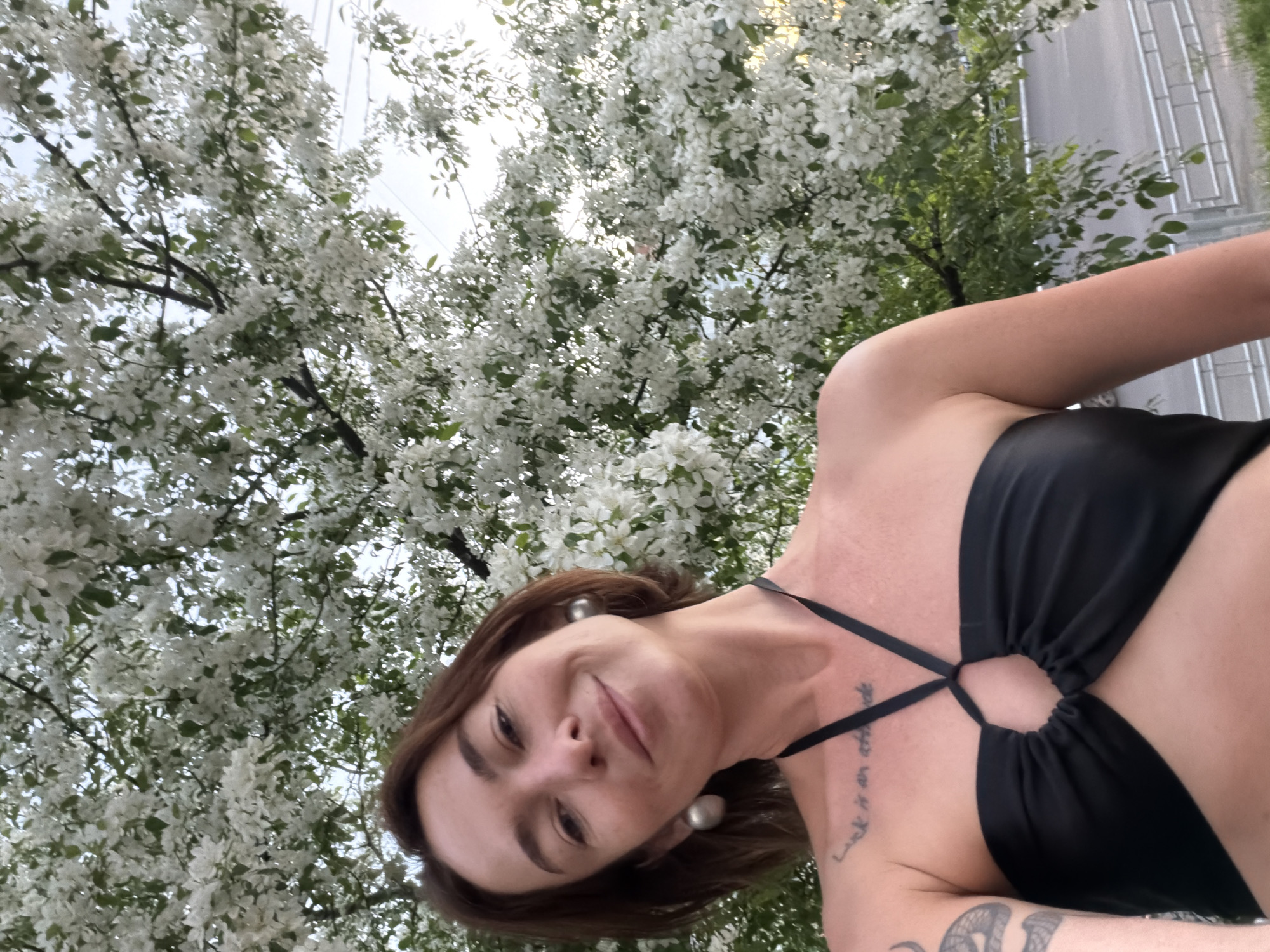 Woman poses for selfies amid blooming trees in Ust-Ilimsk