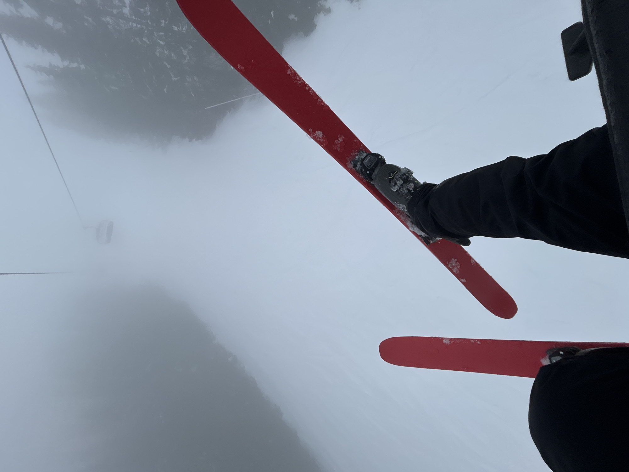 Skier rides lift through fog in Bulgarian mountains