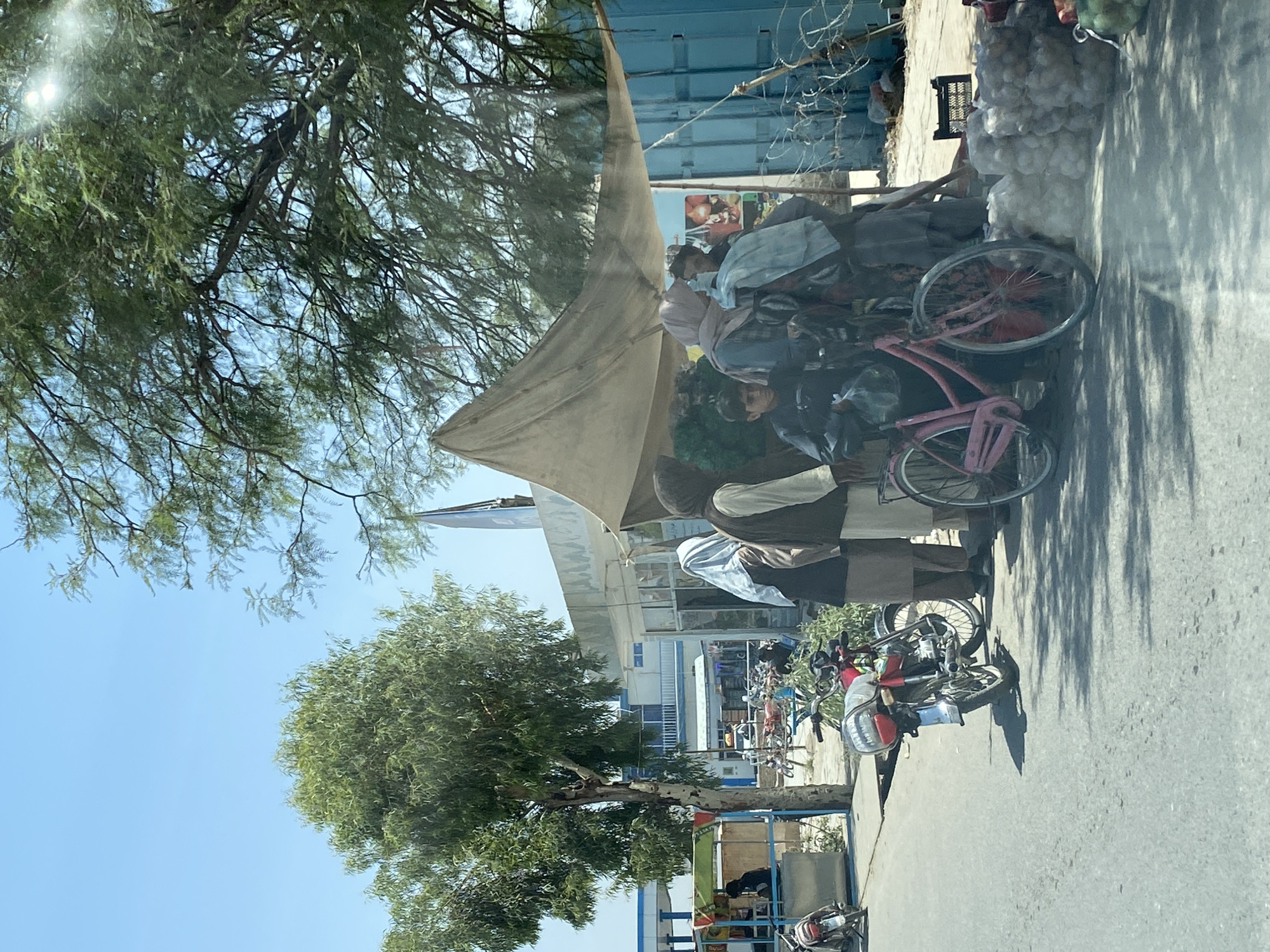 Market activity and parked vehicle on Kandahar street