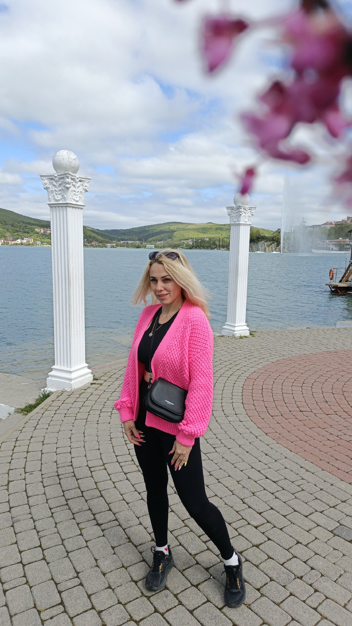 Woman in pink cardigan observed on waterfront promenade in Russia