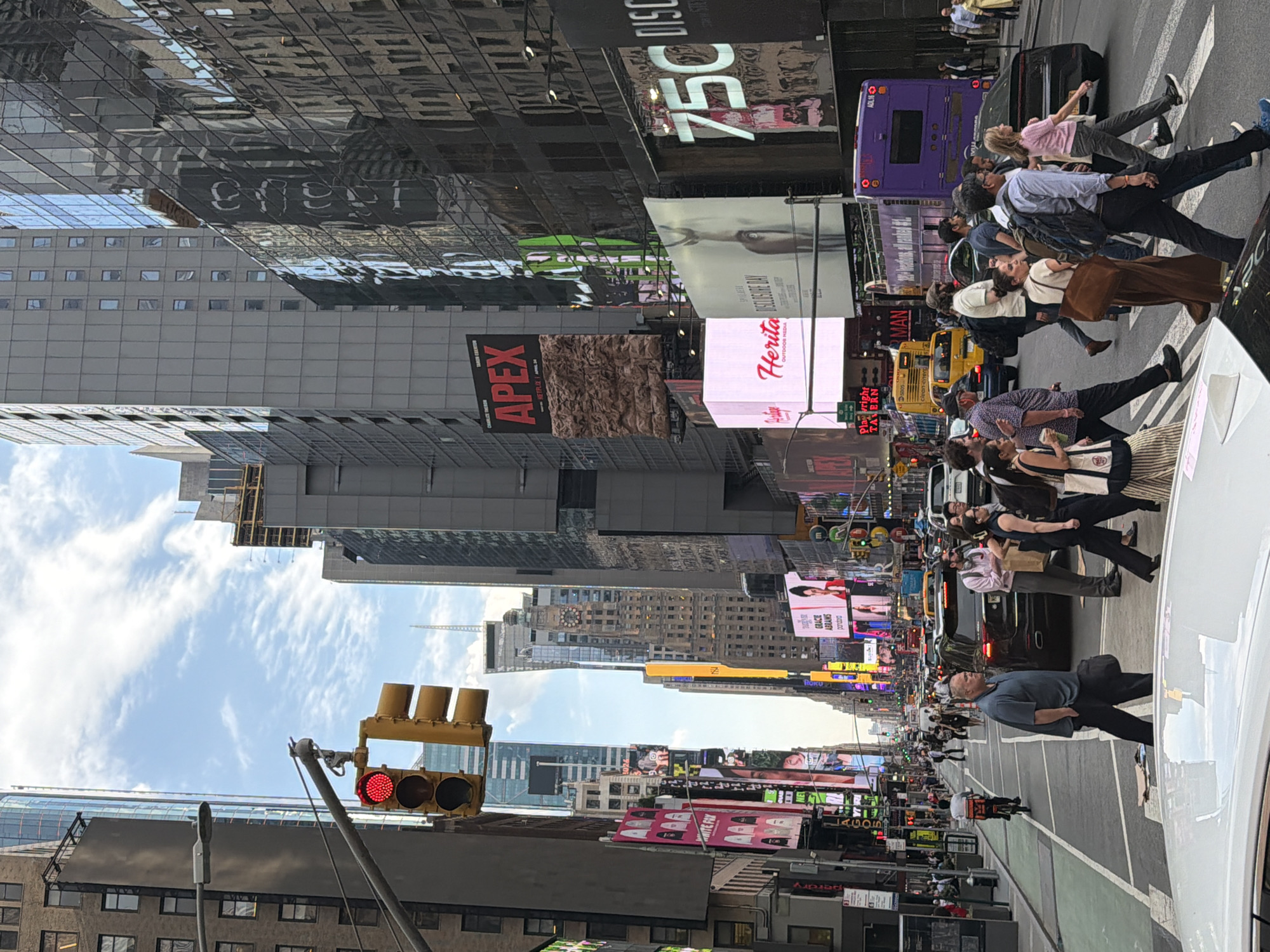 Evening crowds navigate Times Square crosswalks, selfies taken