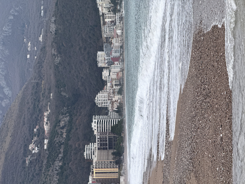Visitor documents overcast beach day along Montenegro's Adriatic coast