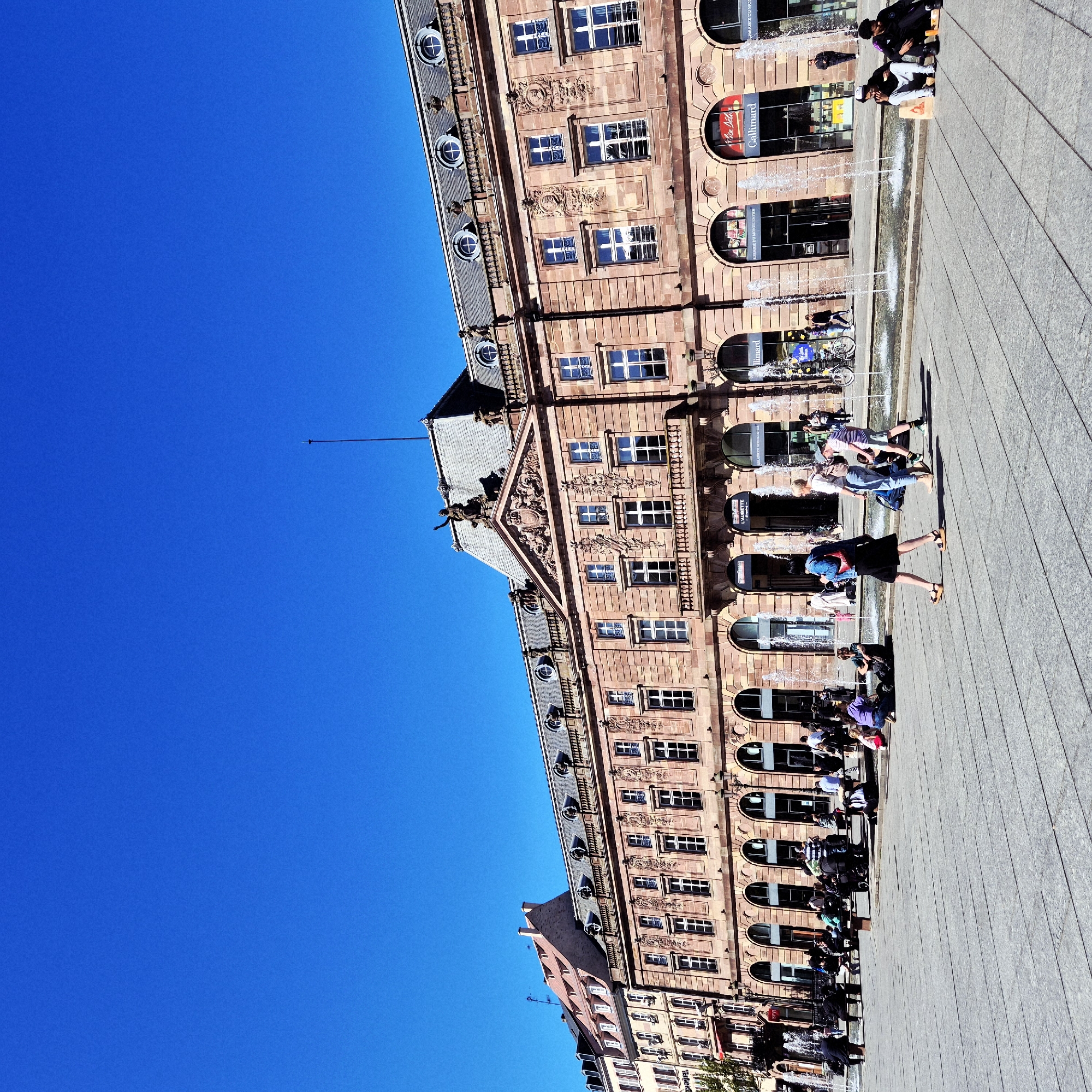 Afternoon gathering captured in Strasbourg public square under clear skies