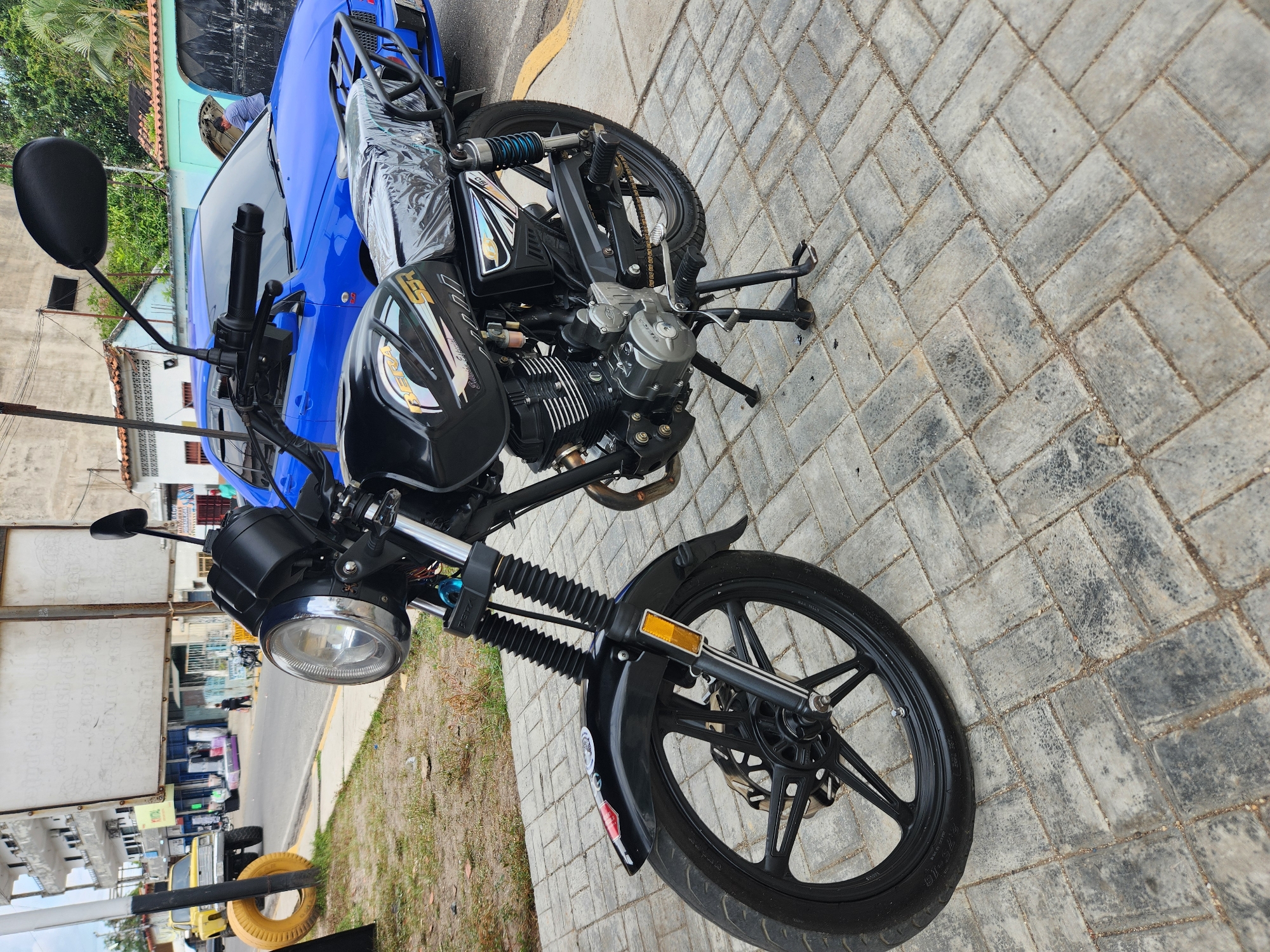 Black motorcycle parked on sidewalk in Tinaquillo, Venezuela