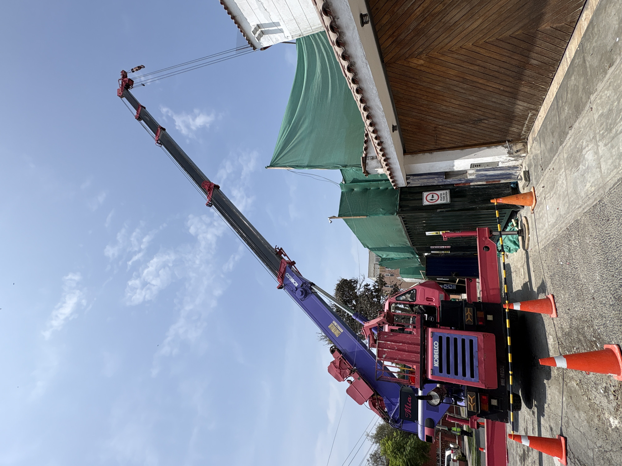 Construction crane operates on Miraflores street with building work