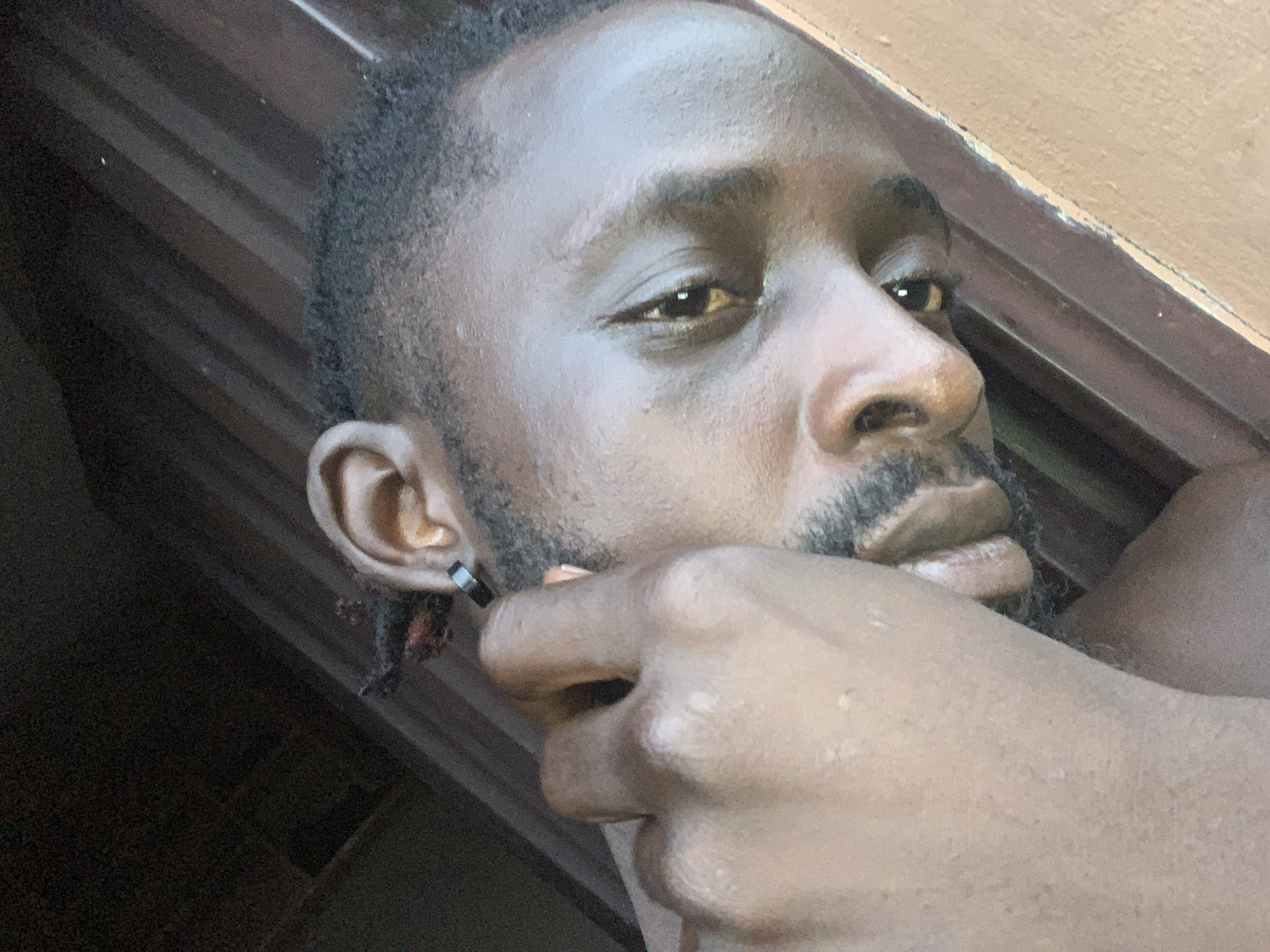 Man photographed with hand covering mouth in Lekki