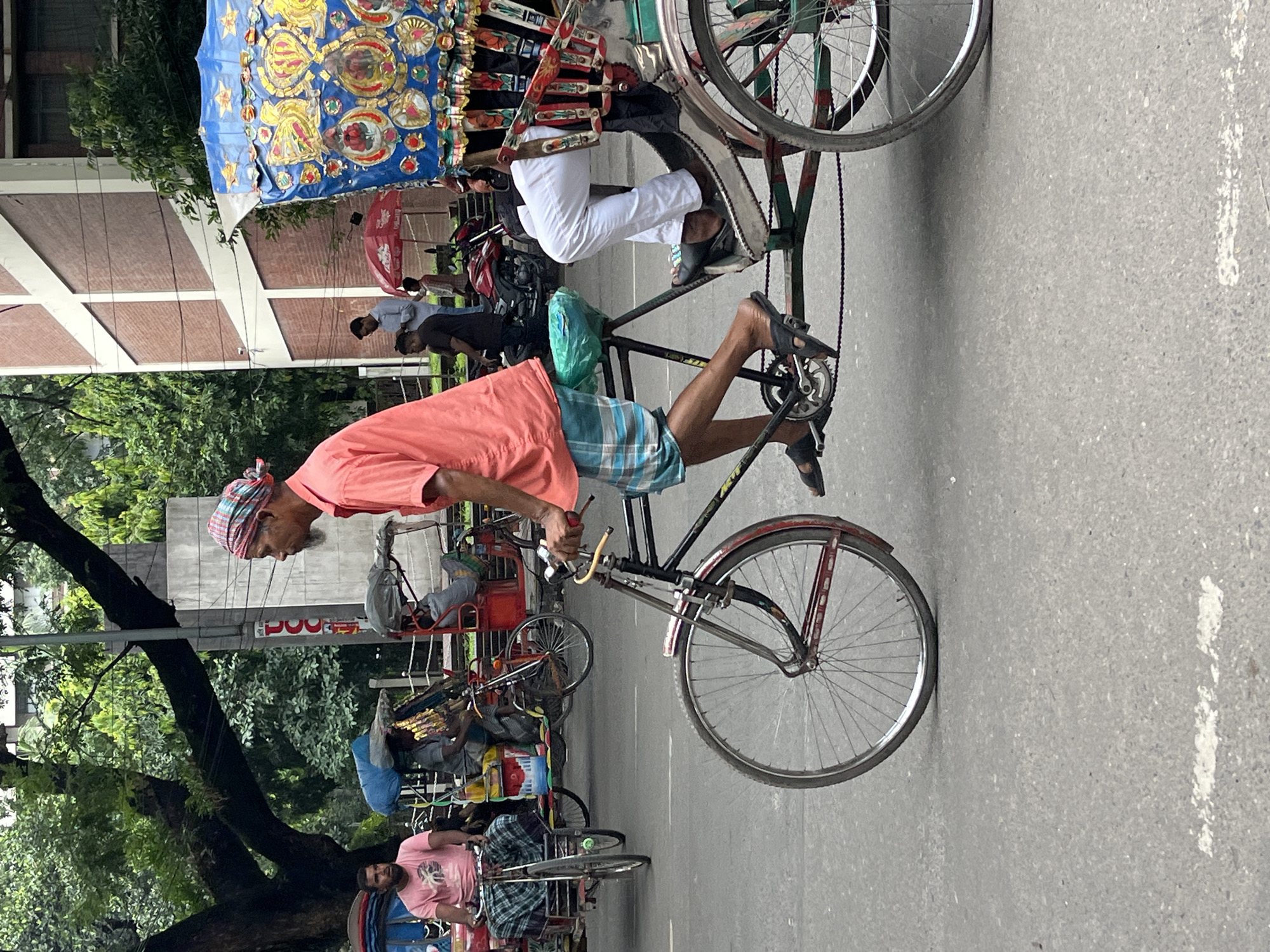 Colorful cycle rickshaws moving through a Dhaka street
