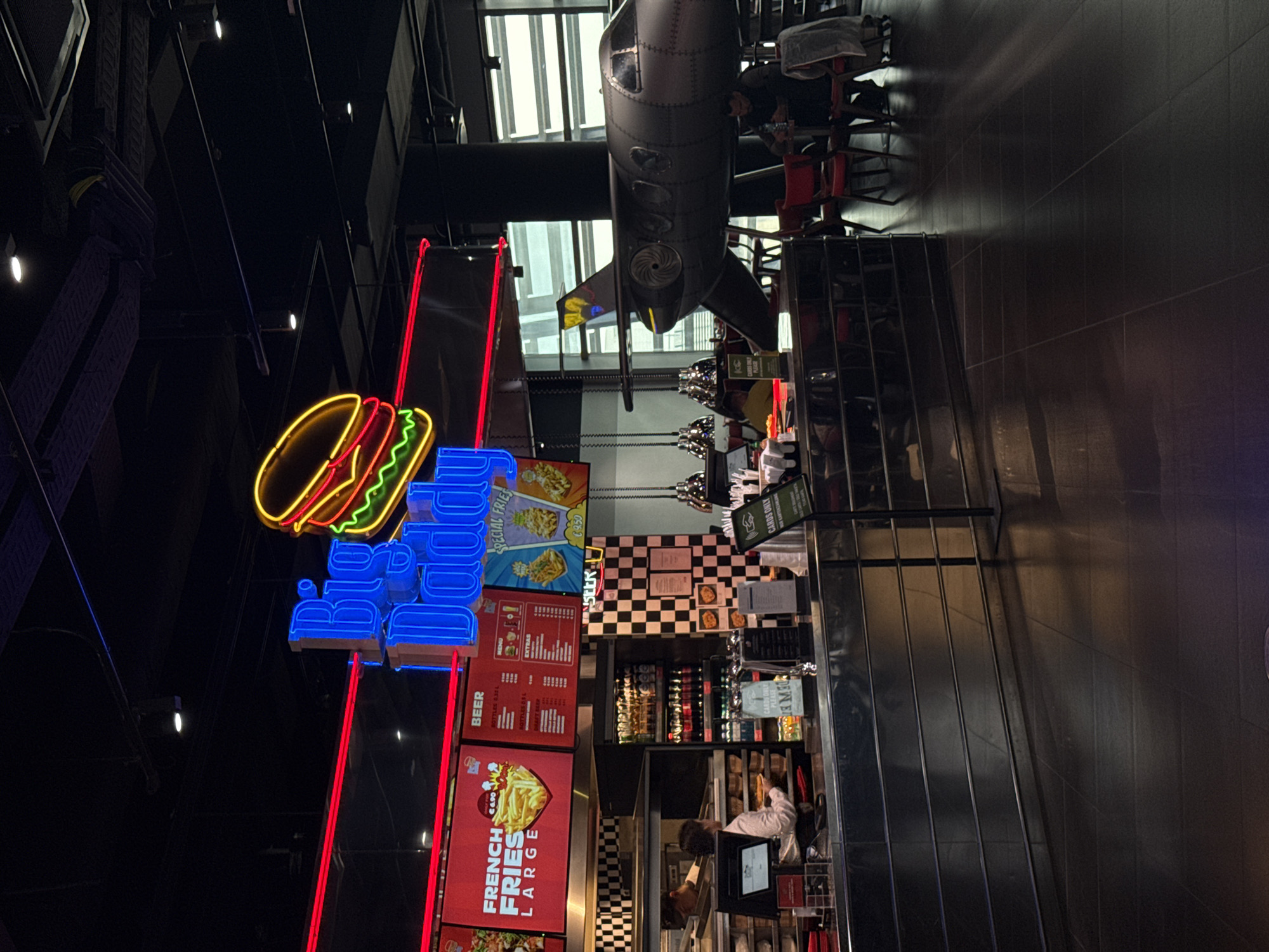 Restaurant interior with illuminated food signage documented in Schwechat