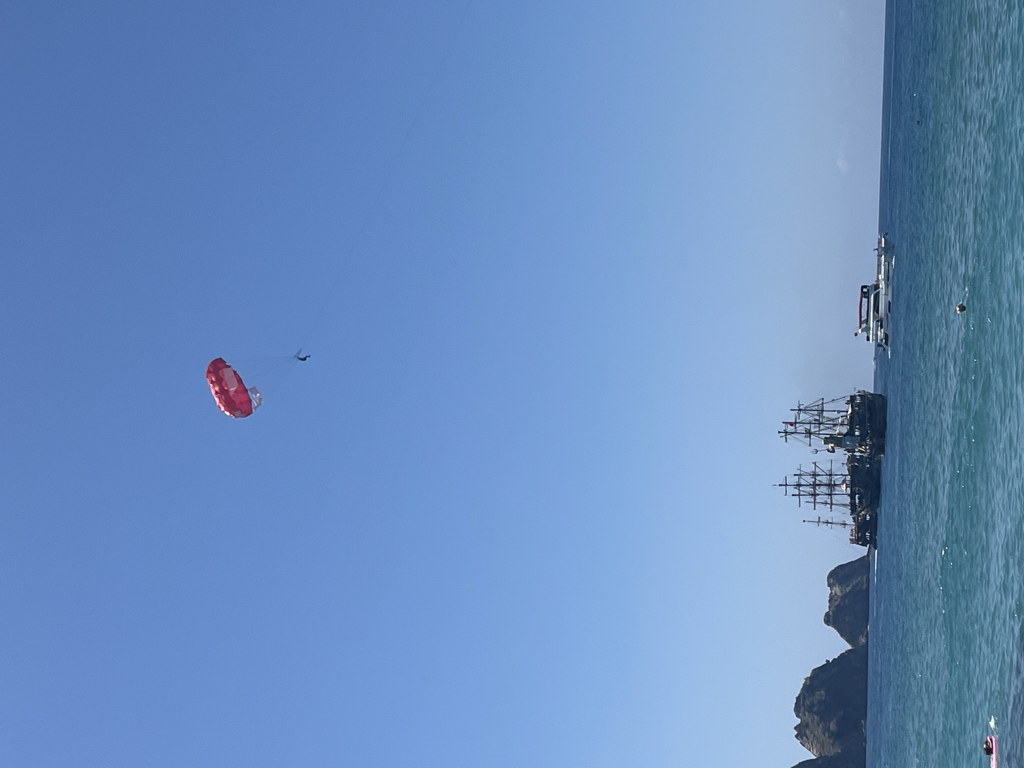 Parasailing activity captured over busy Alanya beach on sunny morning