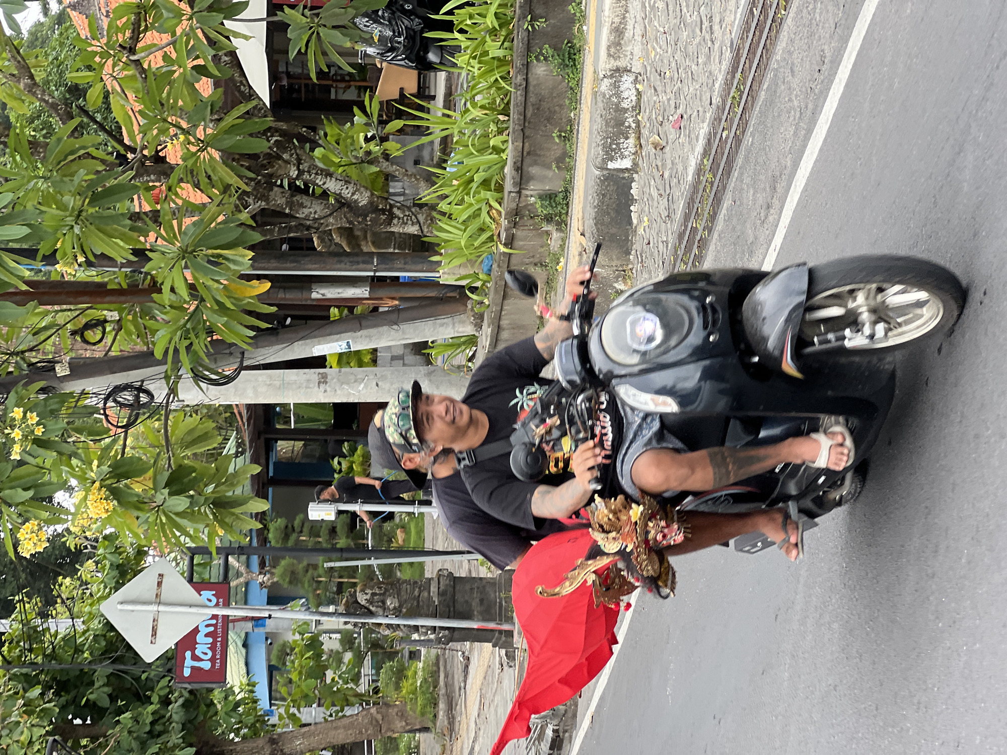 Morning street life in Denpasar — scooters, cyclists, and a garbage run