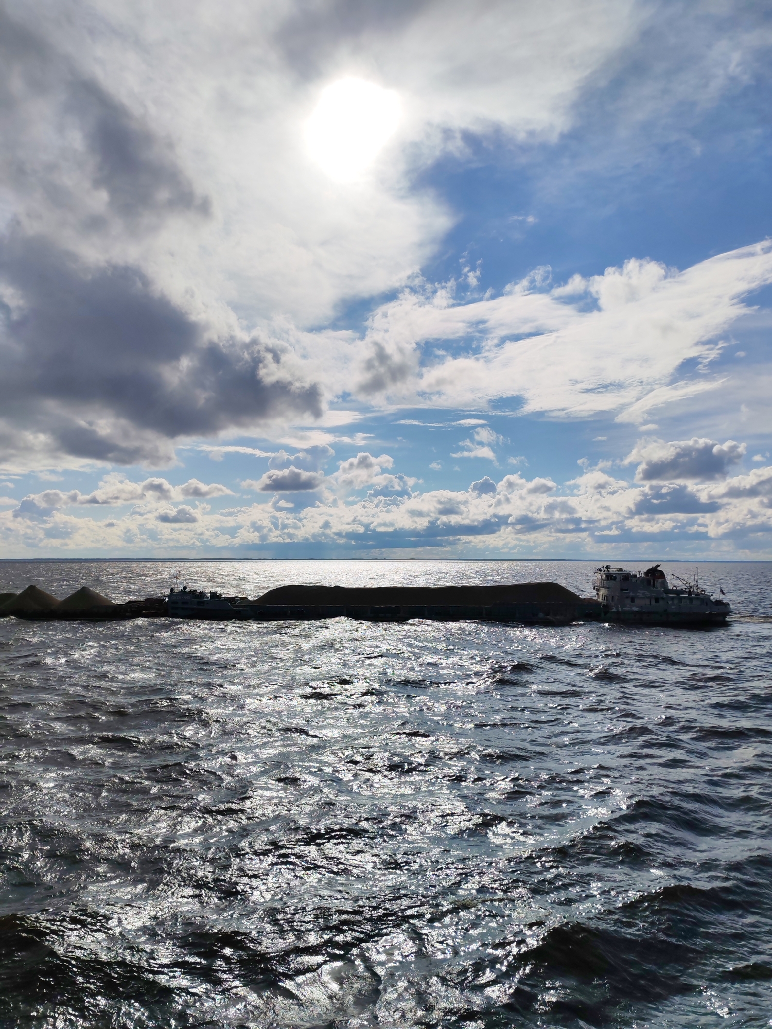 Barges and tugboats working a Russian waterway, rainbow included