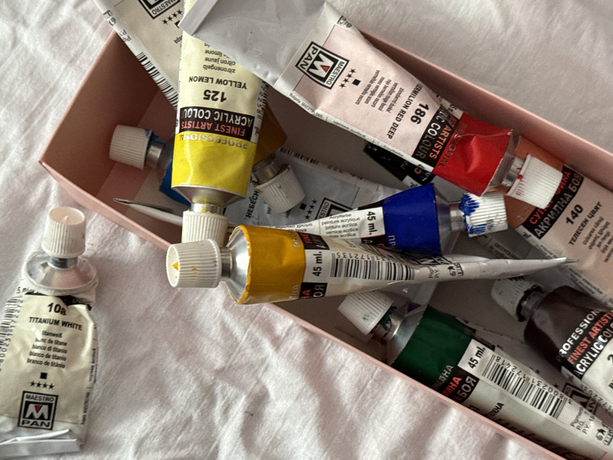 Artist's workspace captured with paints, brushes, and nude paintings
