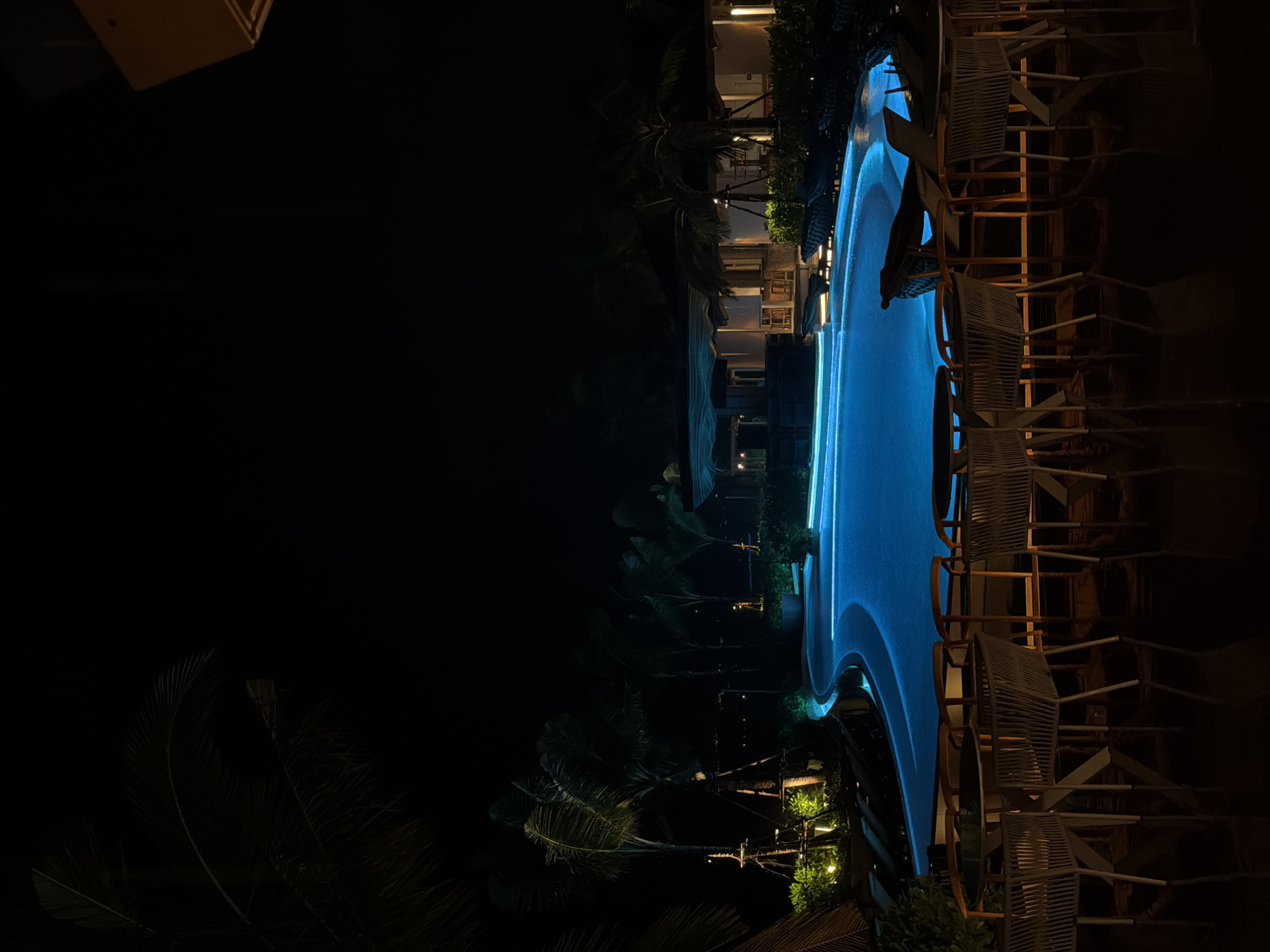 Illuminated pool scene captured at night in Choeng Thale