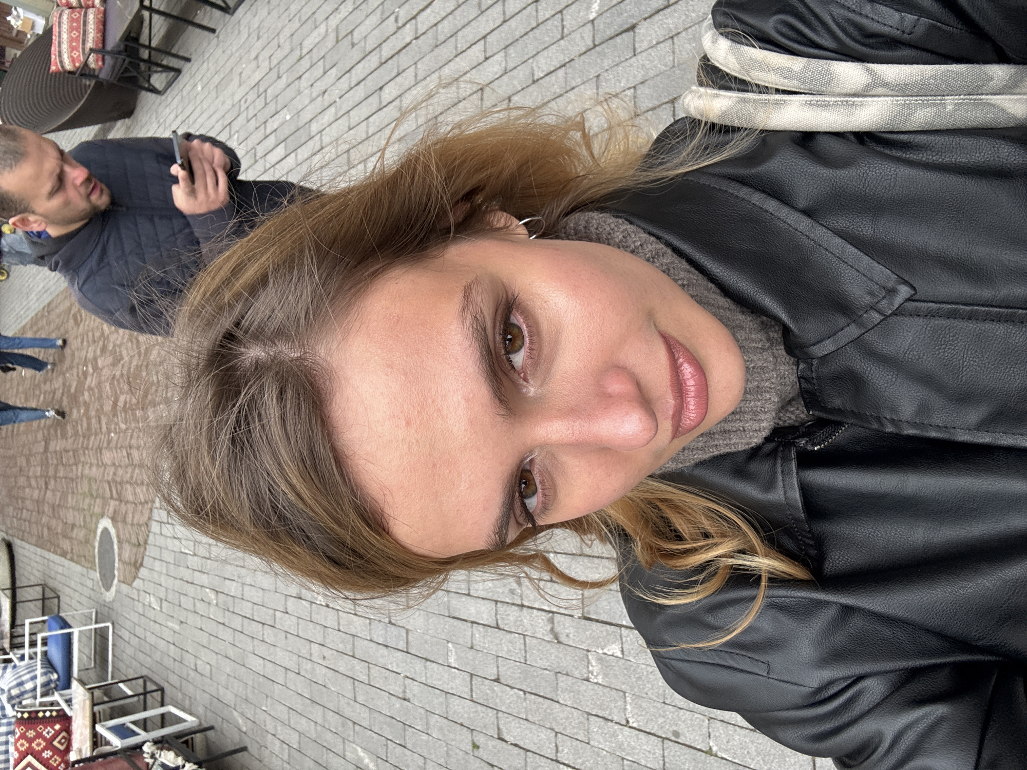 Woman takes selfie in Tbilisi wearing leather jacket