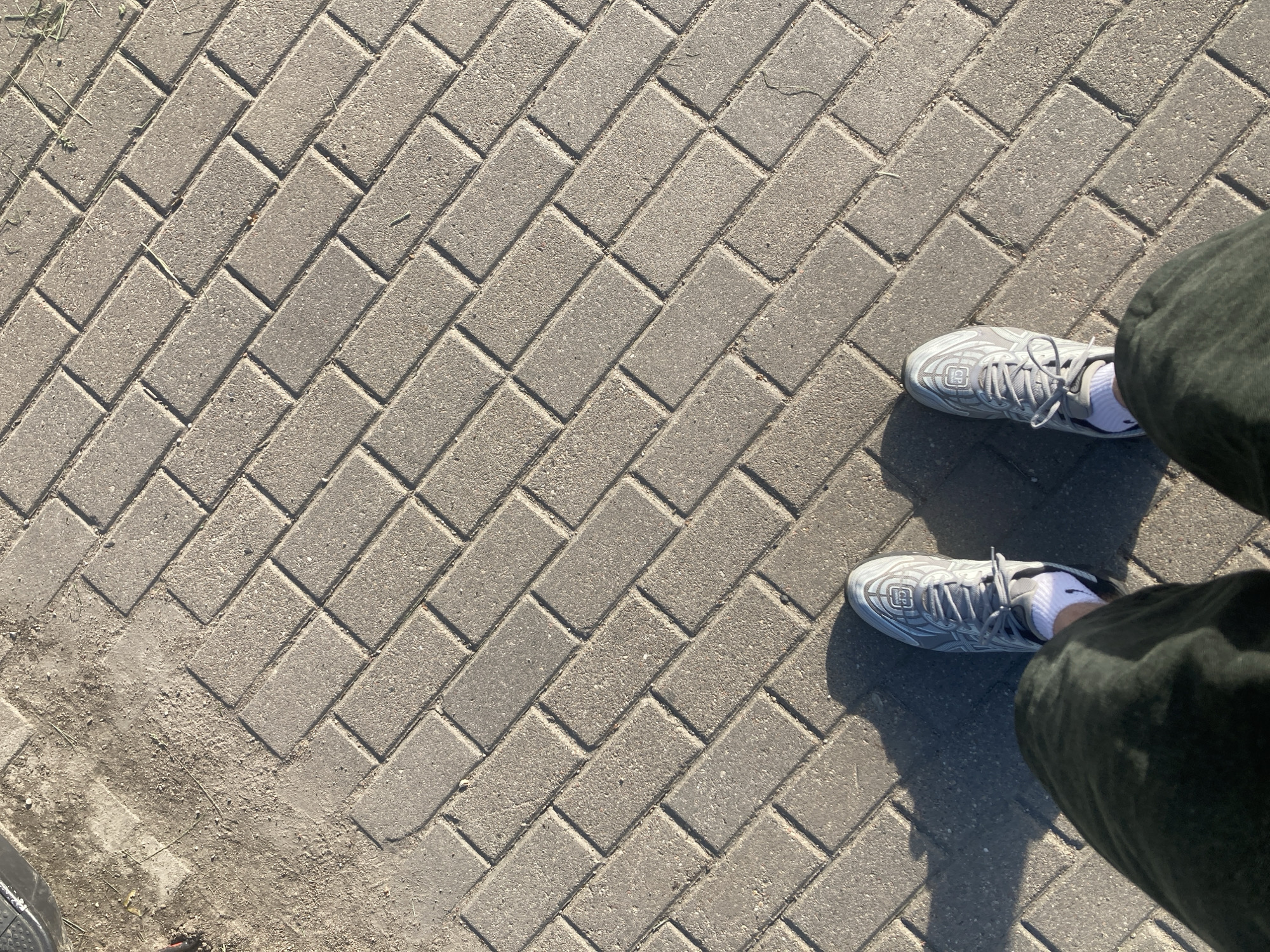 Person photographed standing on herringbone brick pavement in Minsk