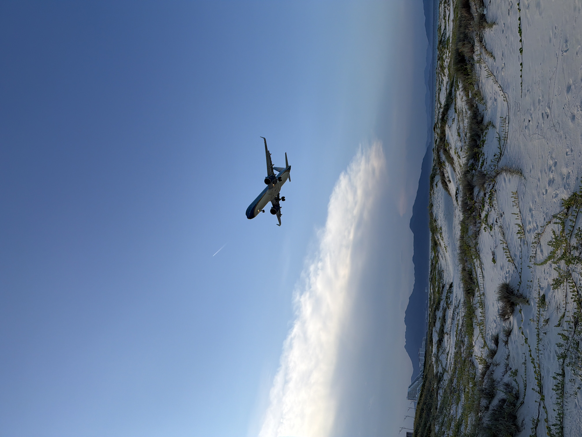 Plane on final approach near Cam Ranh's quiet coastal shoreline