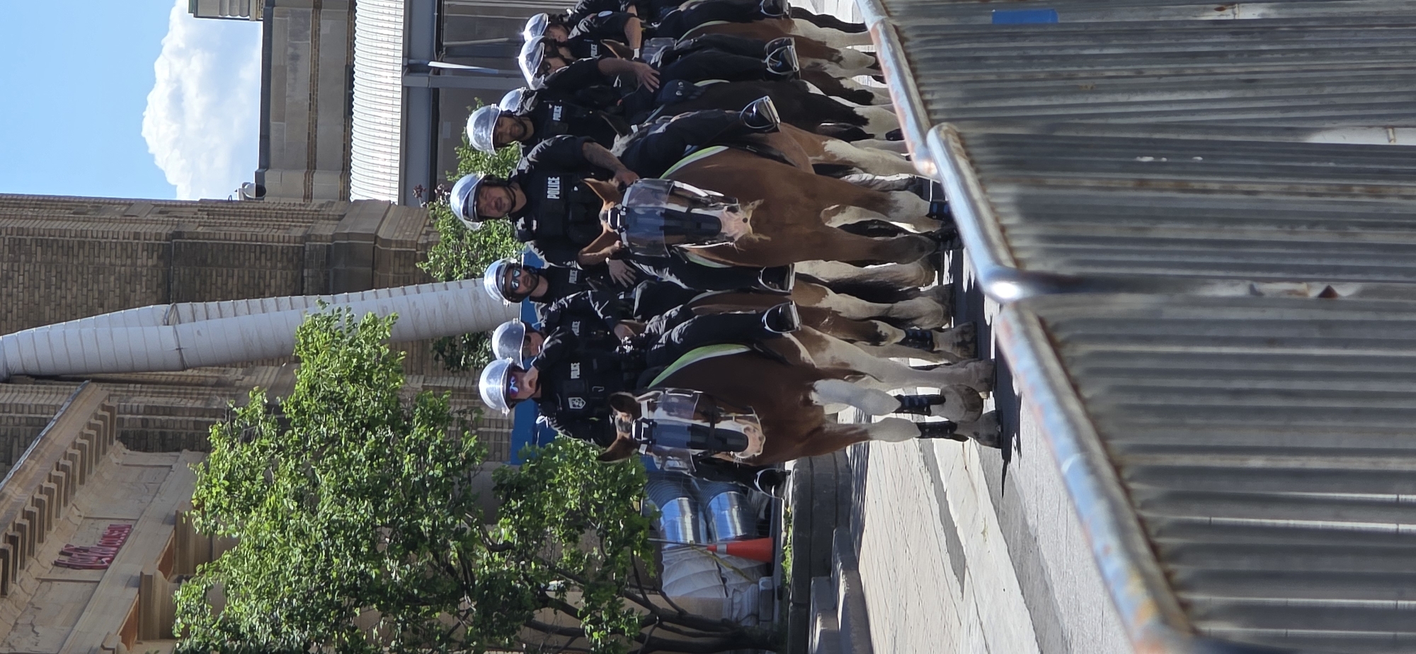 Mounted police and crowds fill downtown Toronto on a sunny day