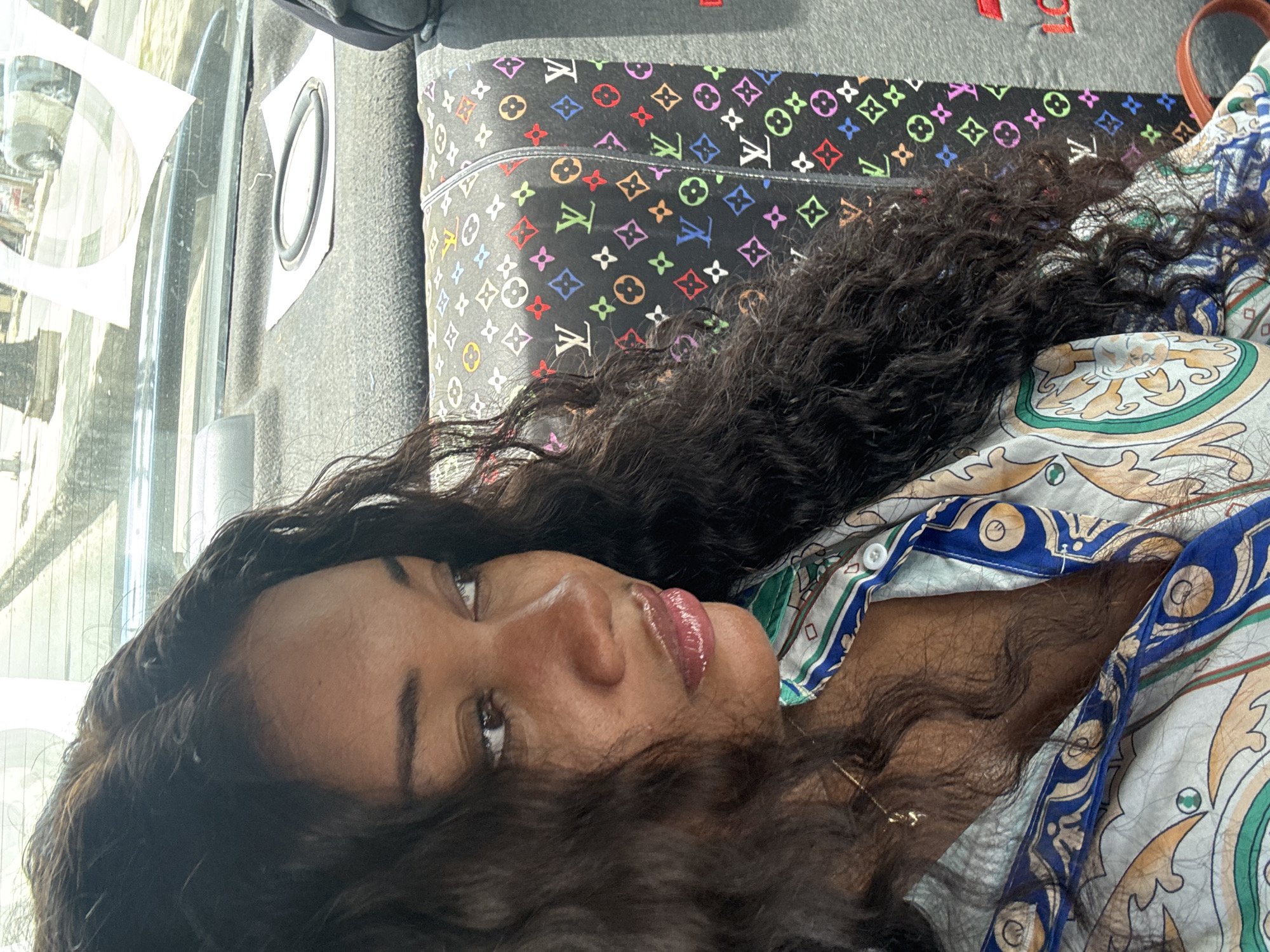 Woman rests in vehicle with designer pillow in Nigeria