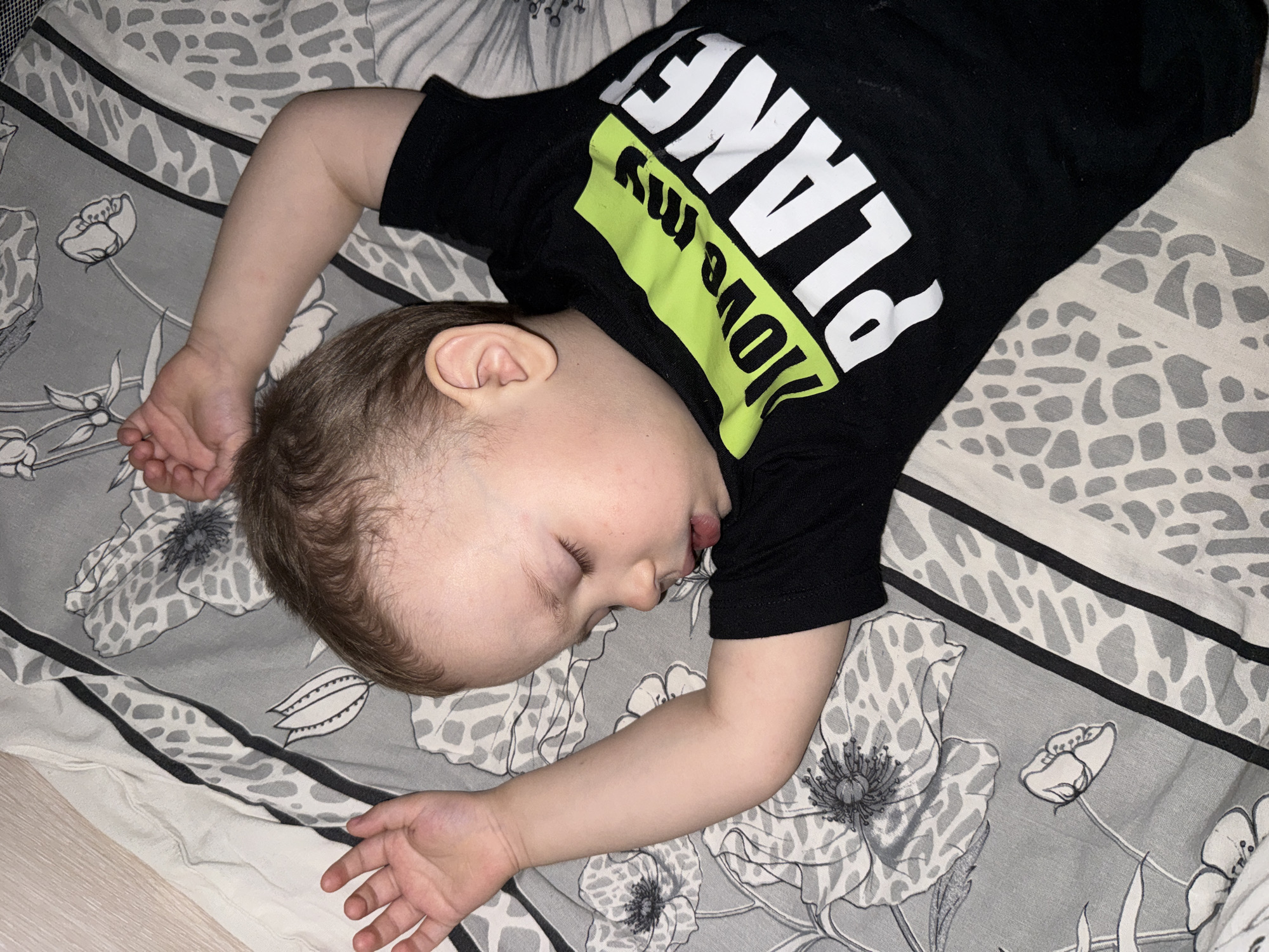 Child sleeps peacefully on patterned bedding in Rusanovo