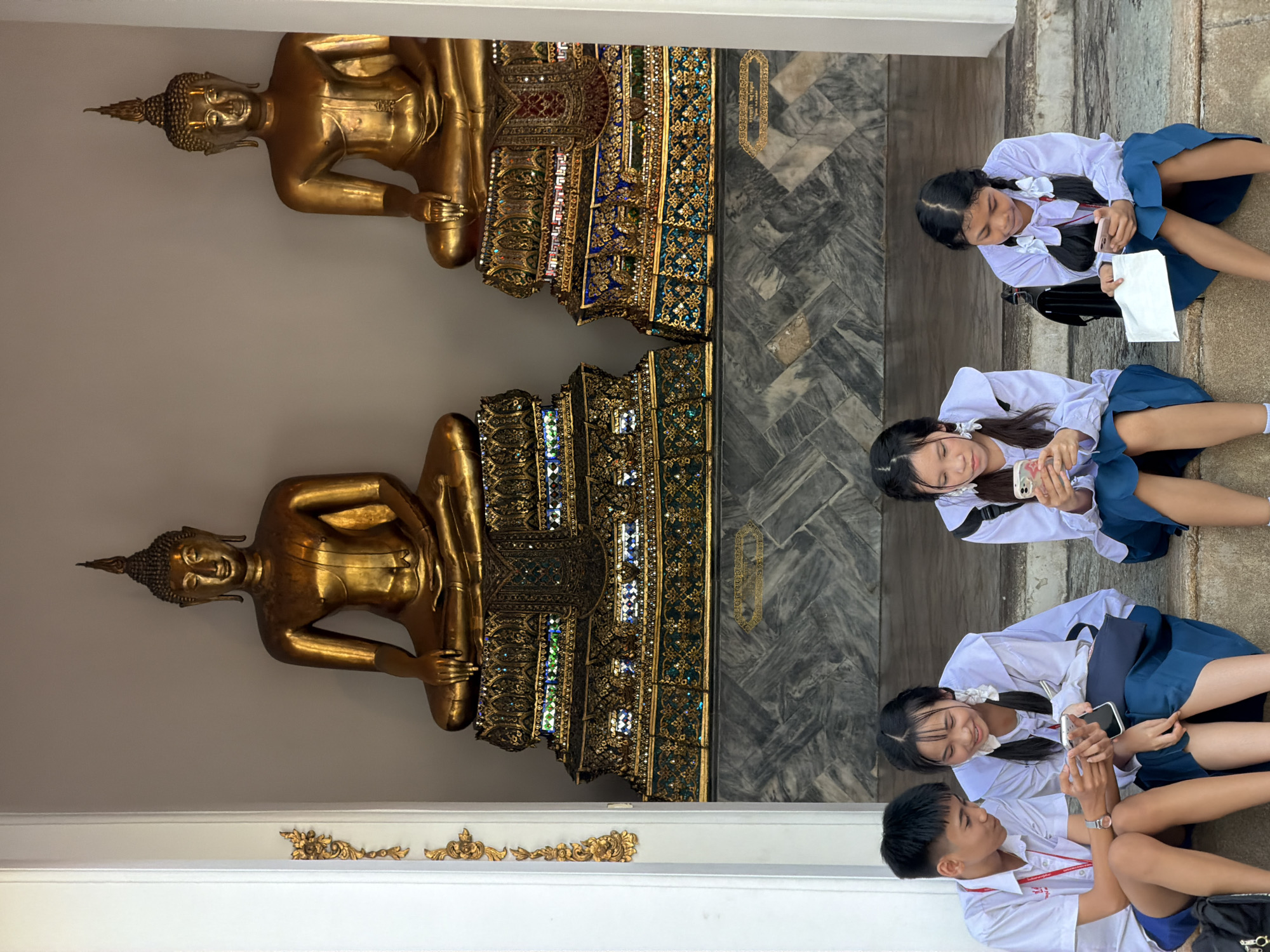 School visit to a Bangkok temple lined with golden Buddha statues