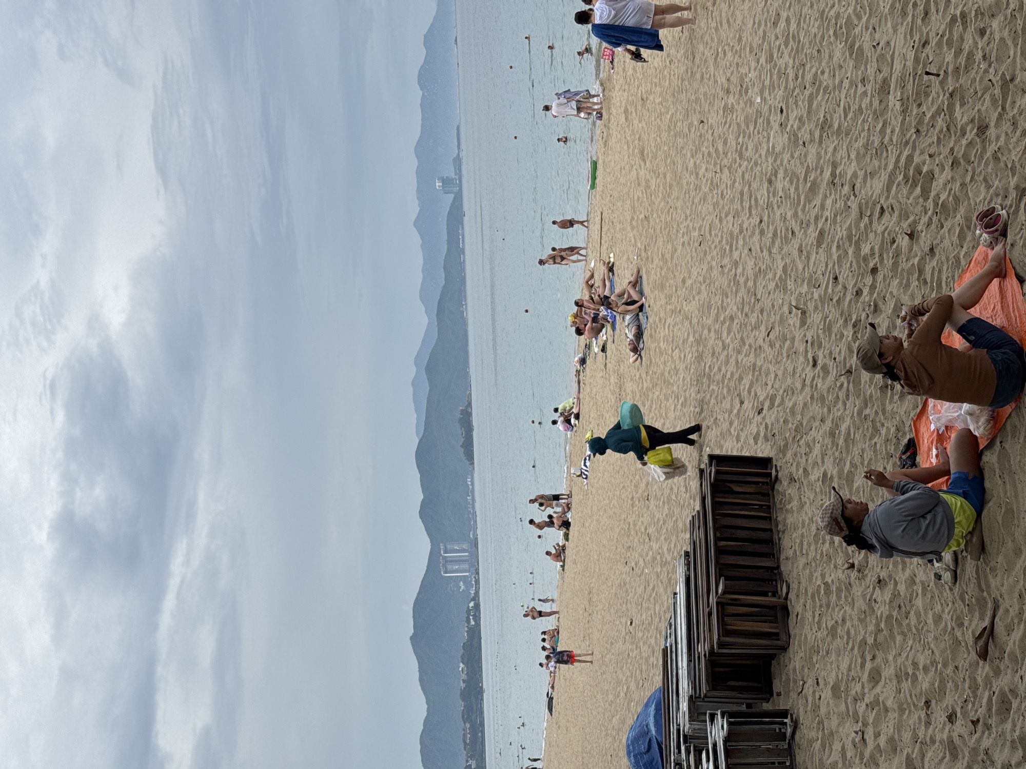 Crowded morning at Nha Trang beach, overcast skies, full shoreline