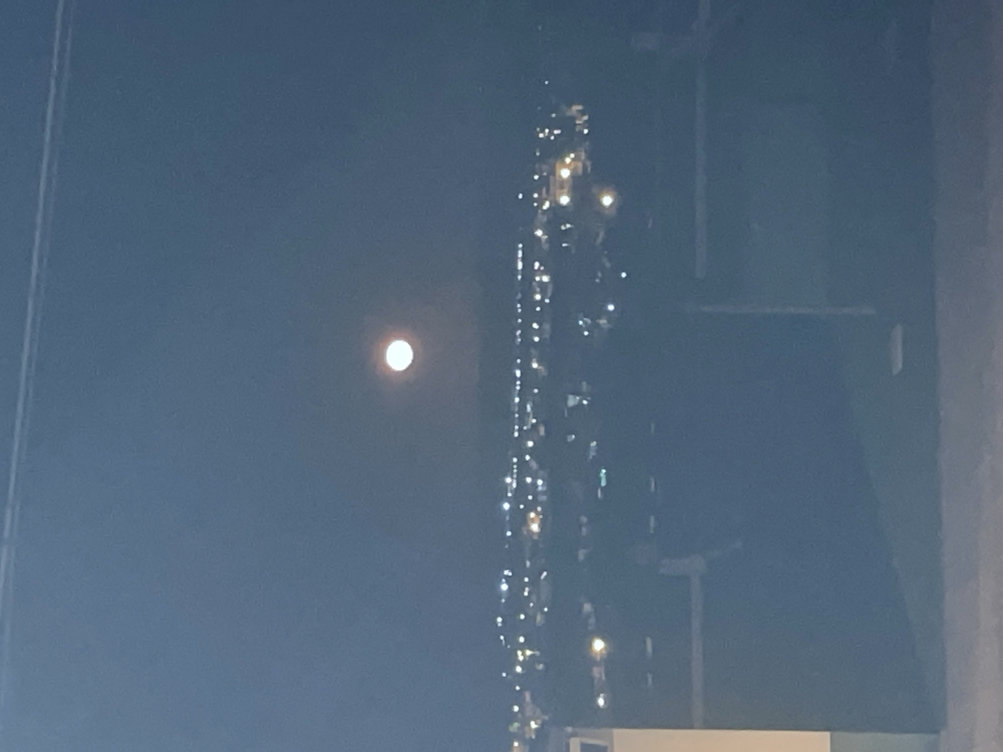 Nighttime moon and illuminated structure photographed in Rojales, Spain