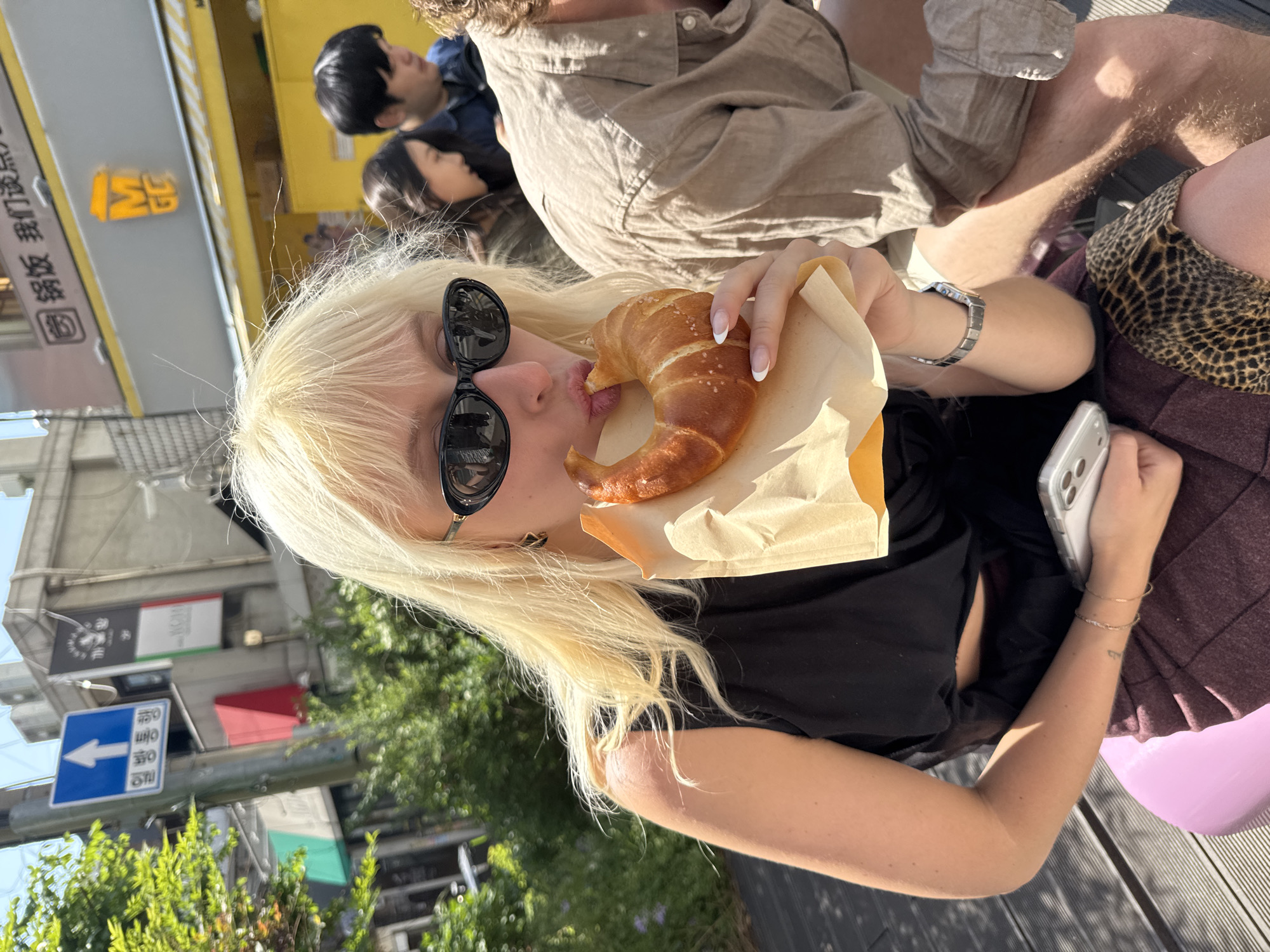 Seoul residents share branded pastries in sunny outdoor setting