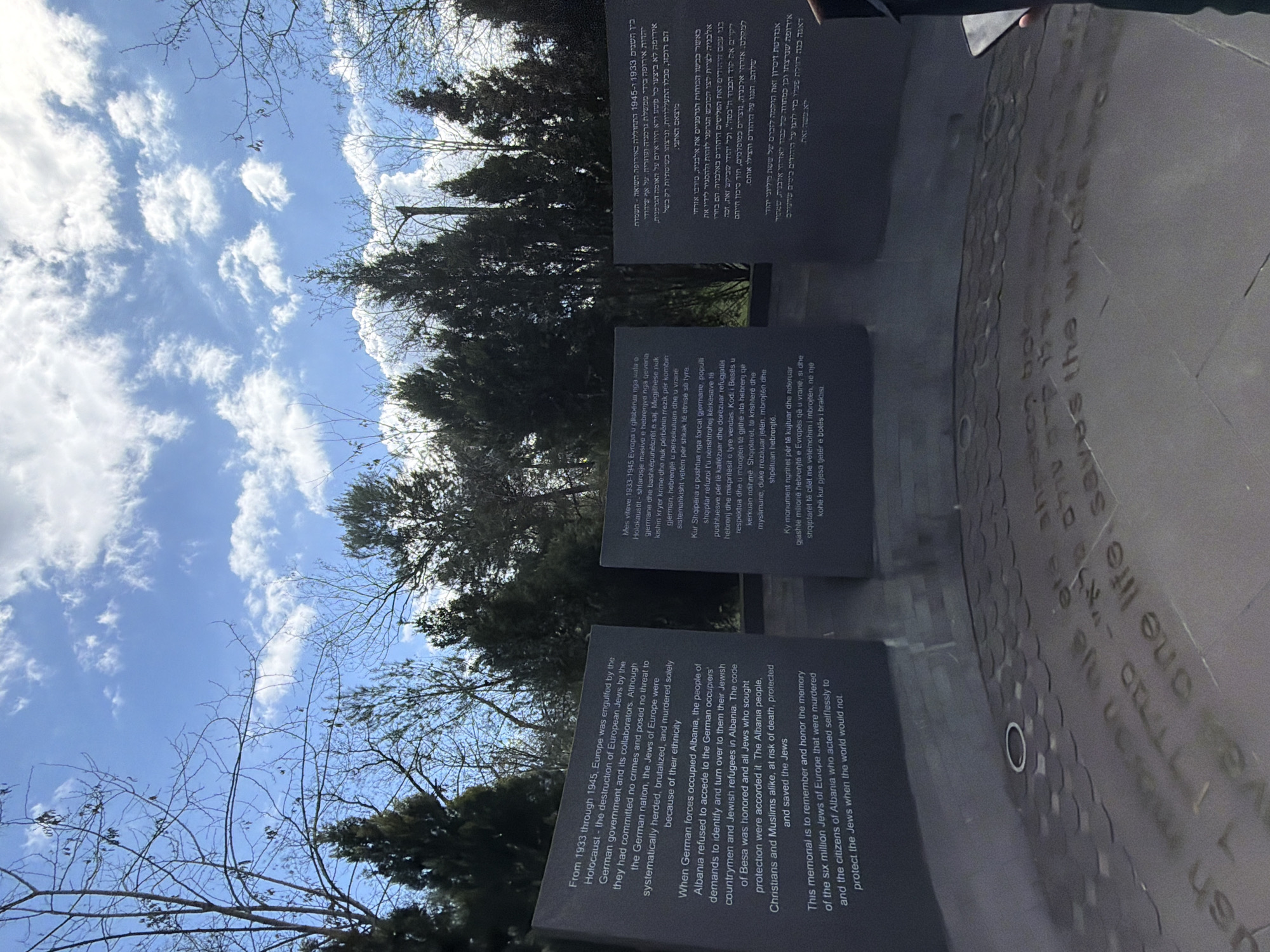 Holocaust memorial visited, street musician performs in Tirana park