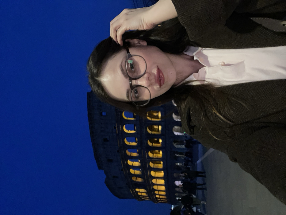Tourist takes nighttime selfie at illuminated Colosseum in Rome