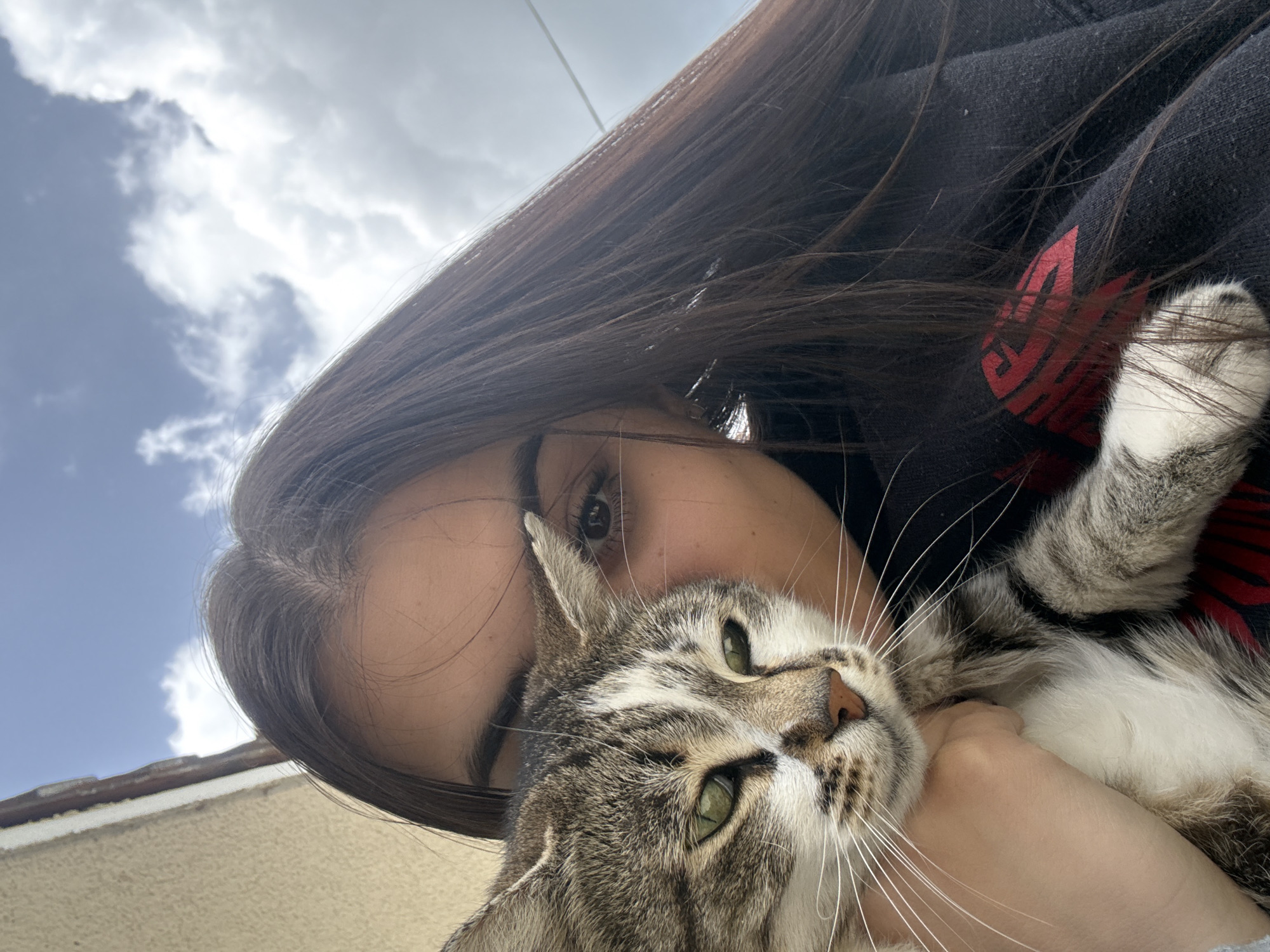 Woman photographed with cat, taking mirror selfie in Polena