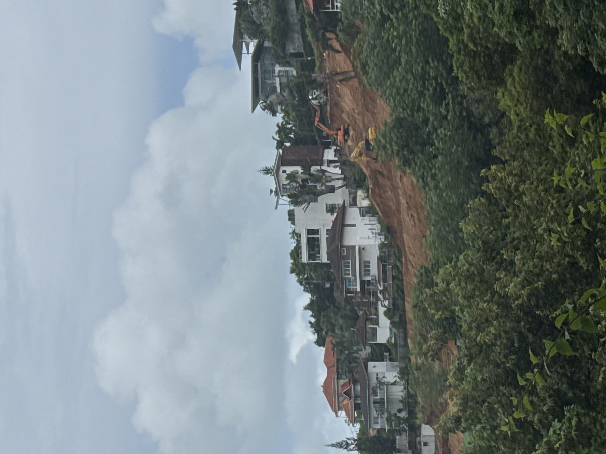 Rawai hillside: resorts, construction, and tropical greenery under grey skies