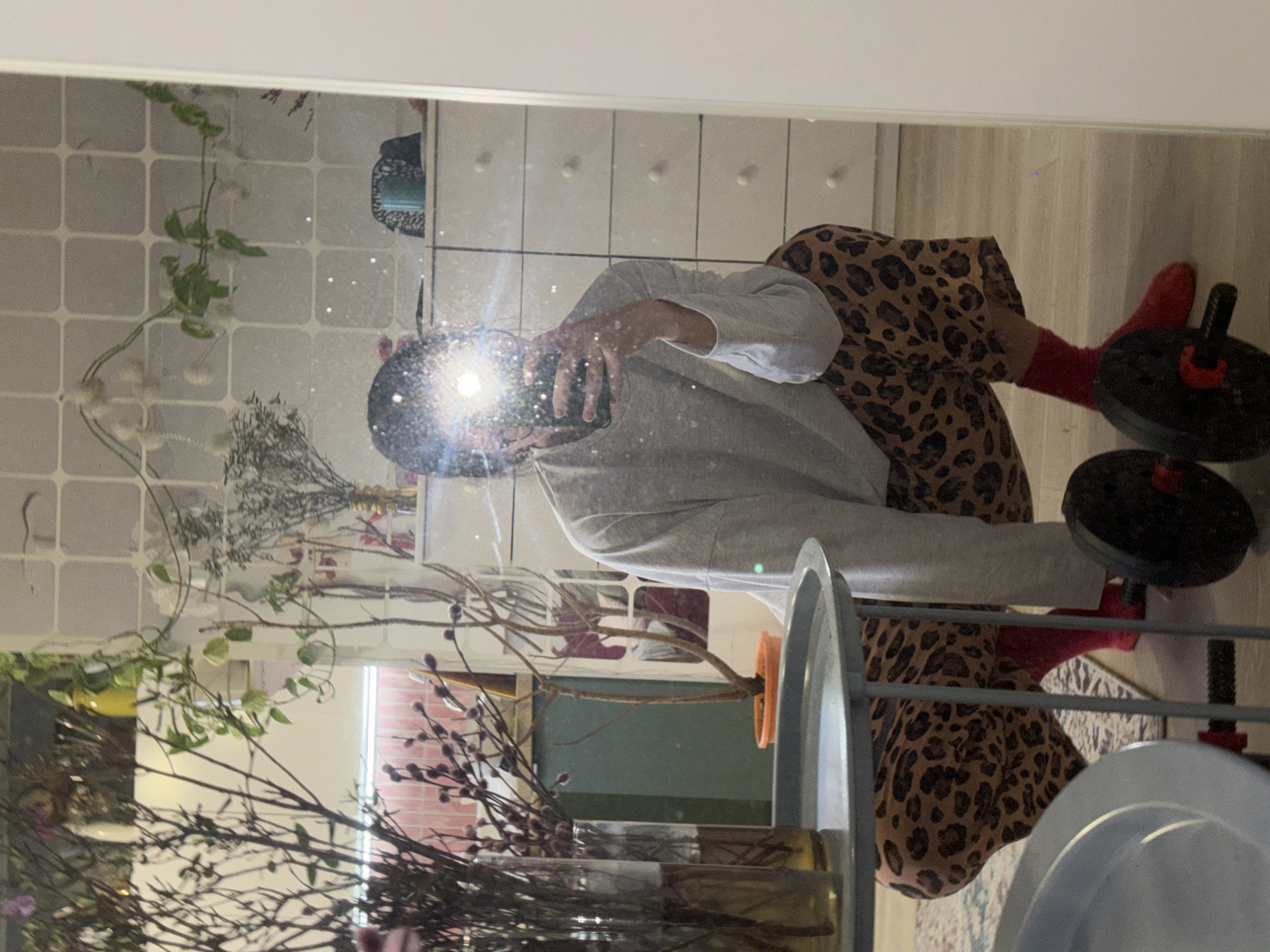 Person takes mirror selfie in leopard pants in Krasnoyarsk home