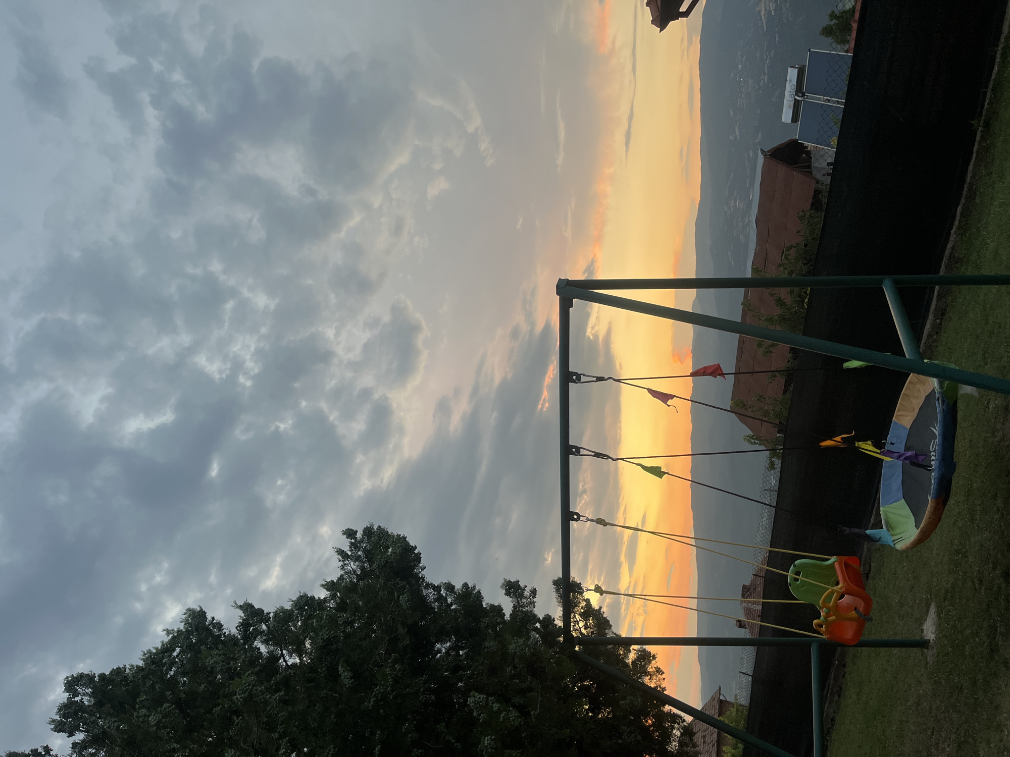 Backyard swing set under a split sunset sky