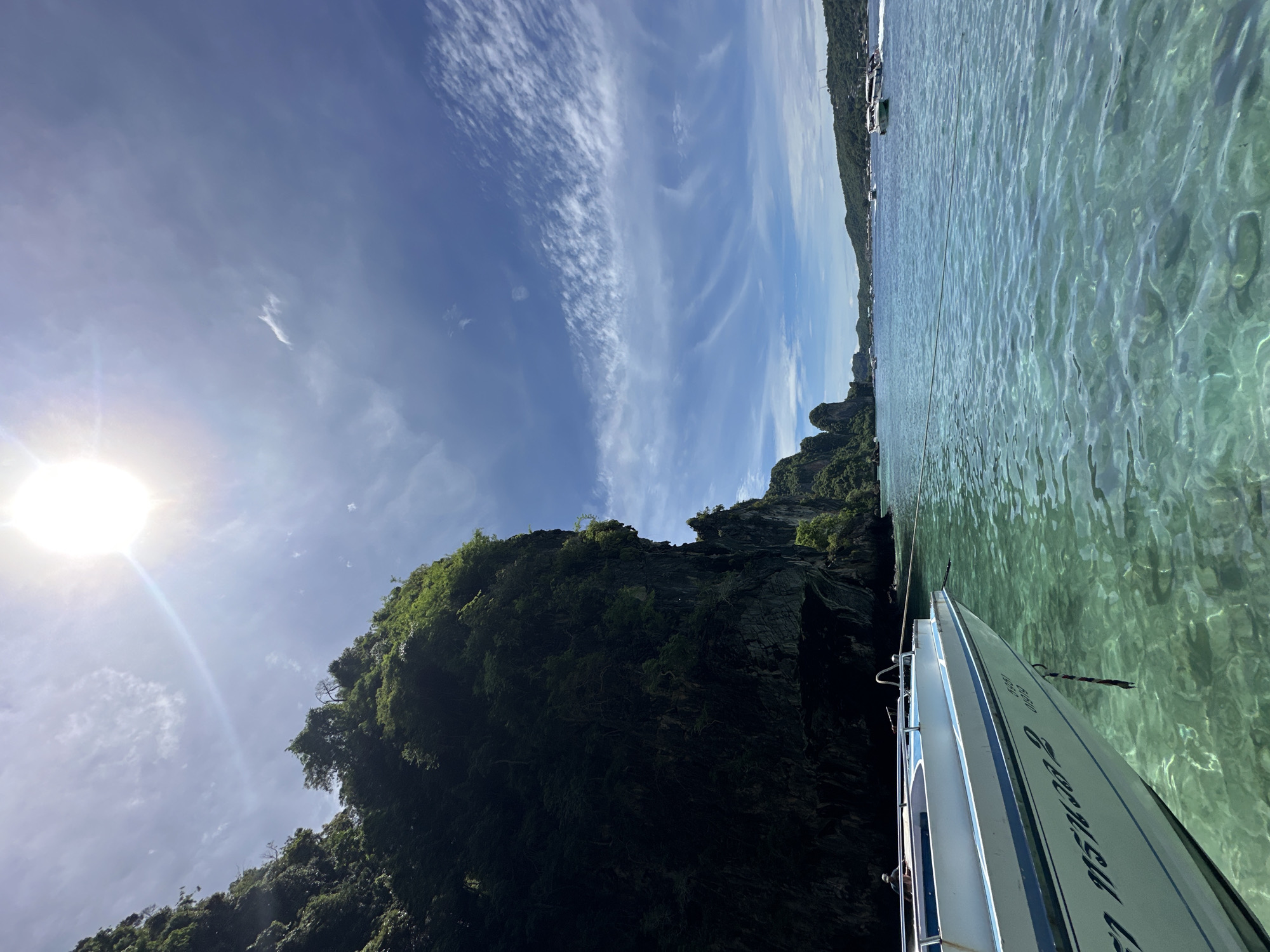 On the water at Haad Hin Khom's rocky coastline