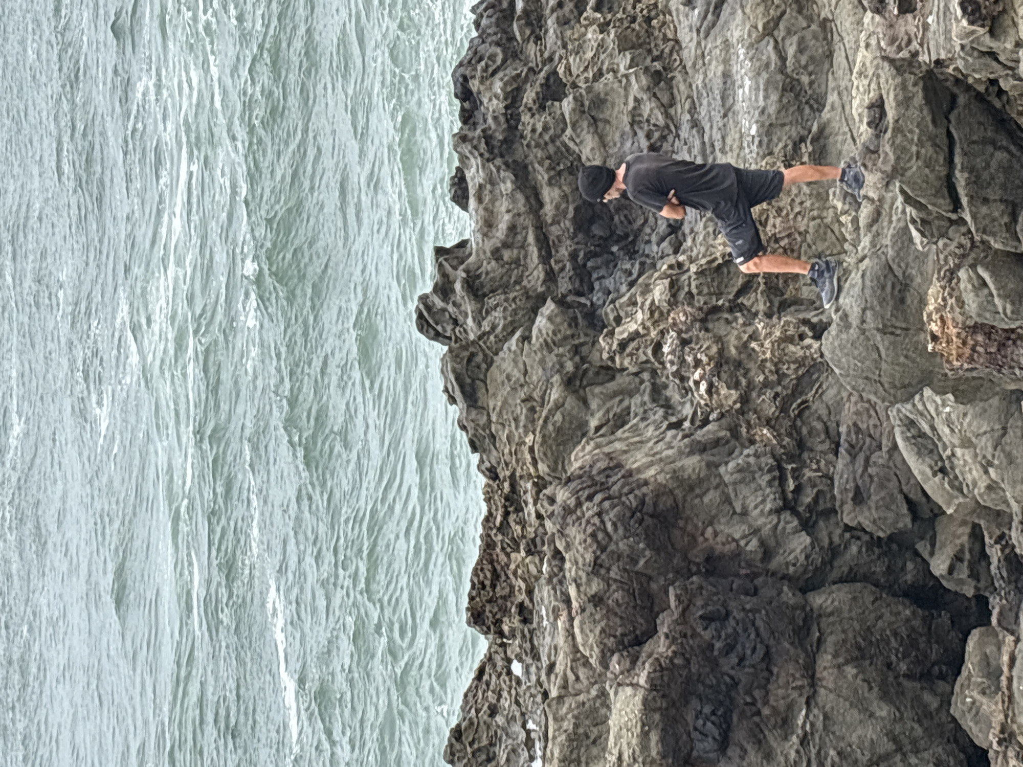 Man explores rocky coastline cliffs in Arica, Chile