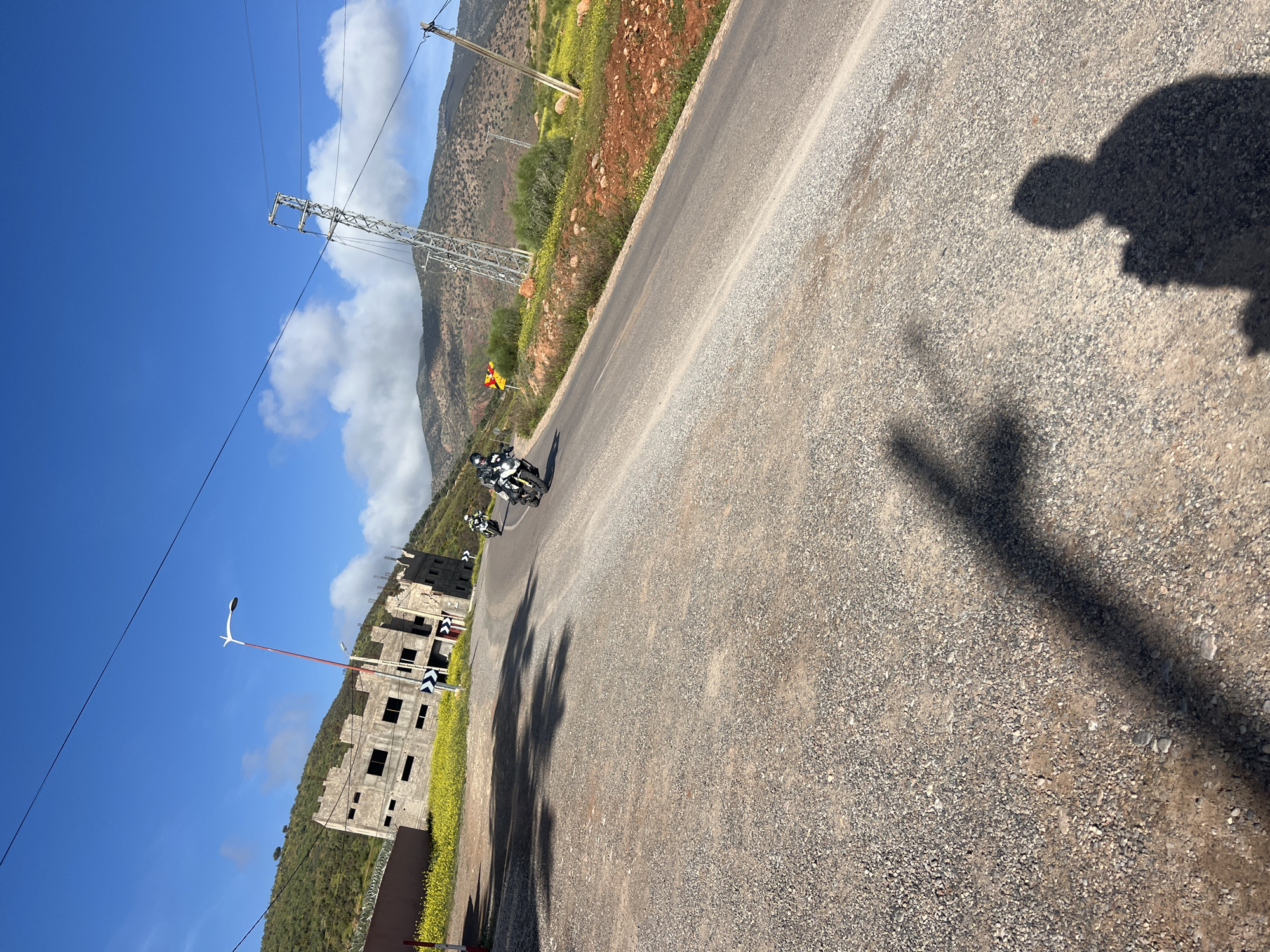 Motorcyclists travel winding road near Ouaouizert, Morocco