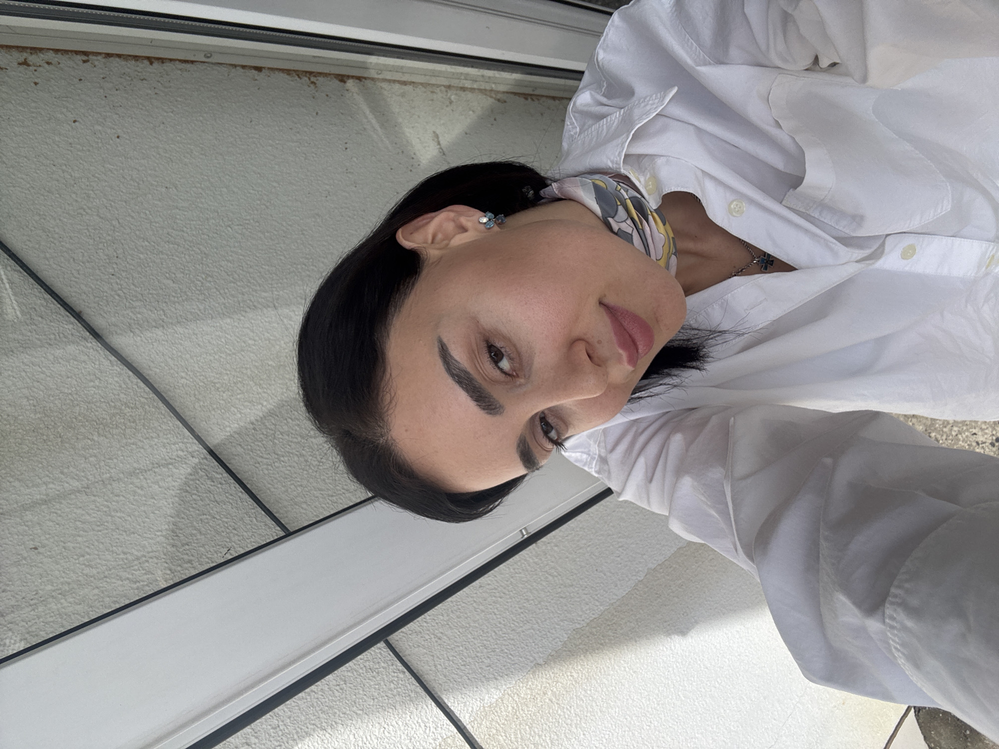 Woman takes selfies in downtown Tbilisi wearing cross necklace