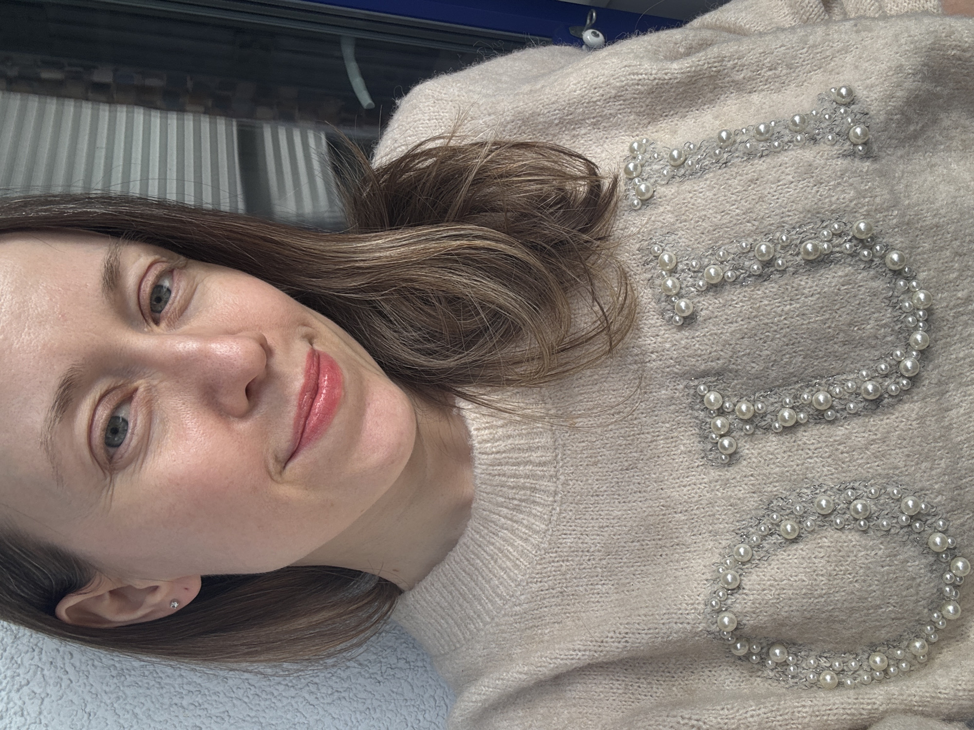 Woman in pearl-embellished sweater photographed in Kudrovo, Russia