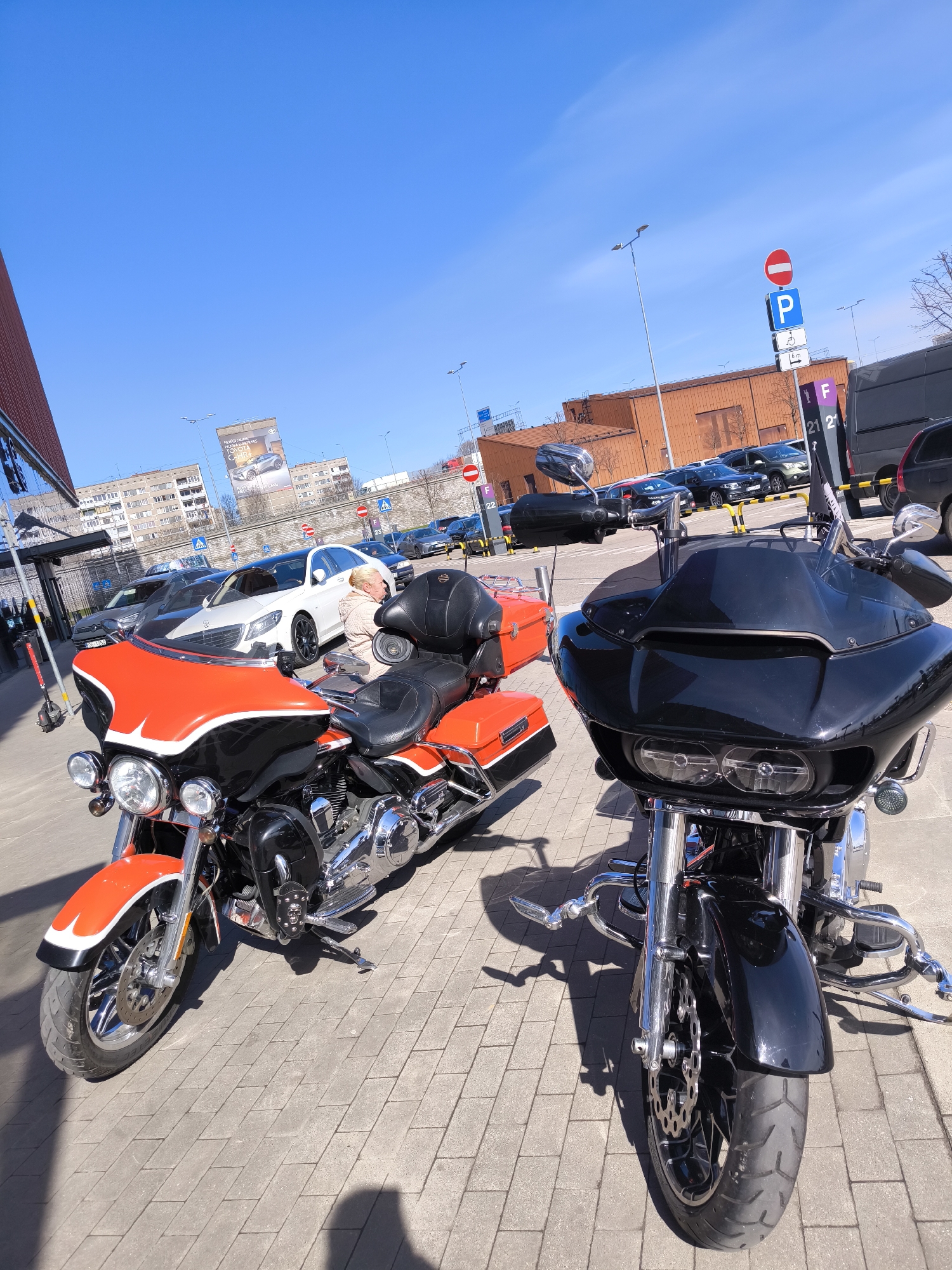 Woman sits on parked Harley-Davidson motorcycles in Riga