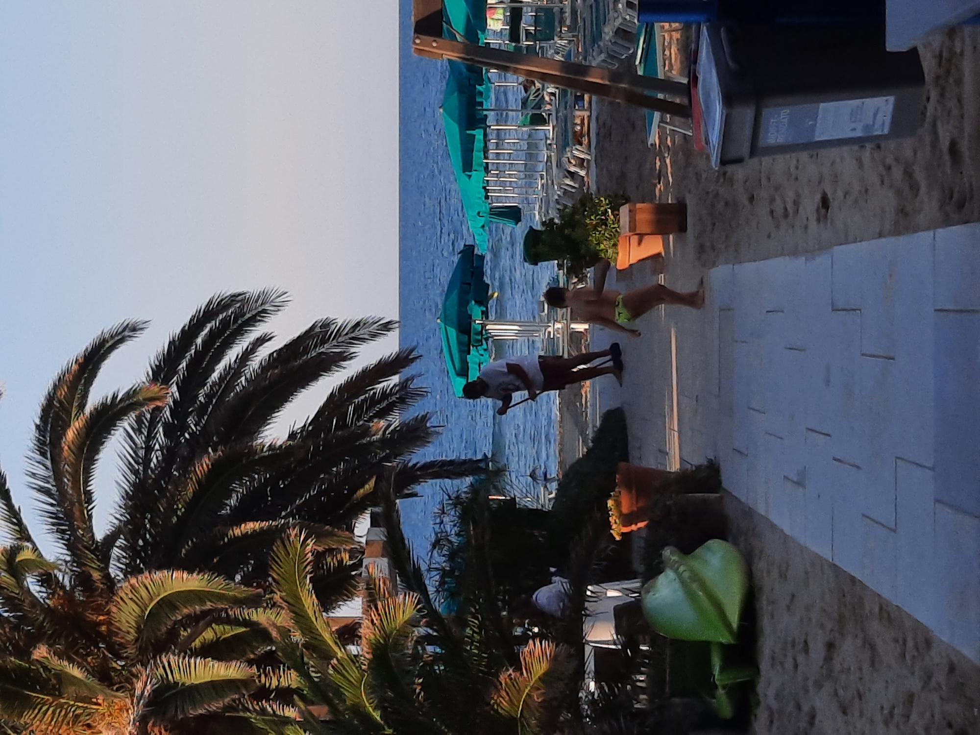Afternoon at Pesaro's beachfront: cafés, bikes, and an Iron Man cutout
