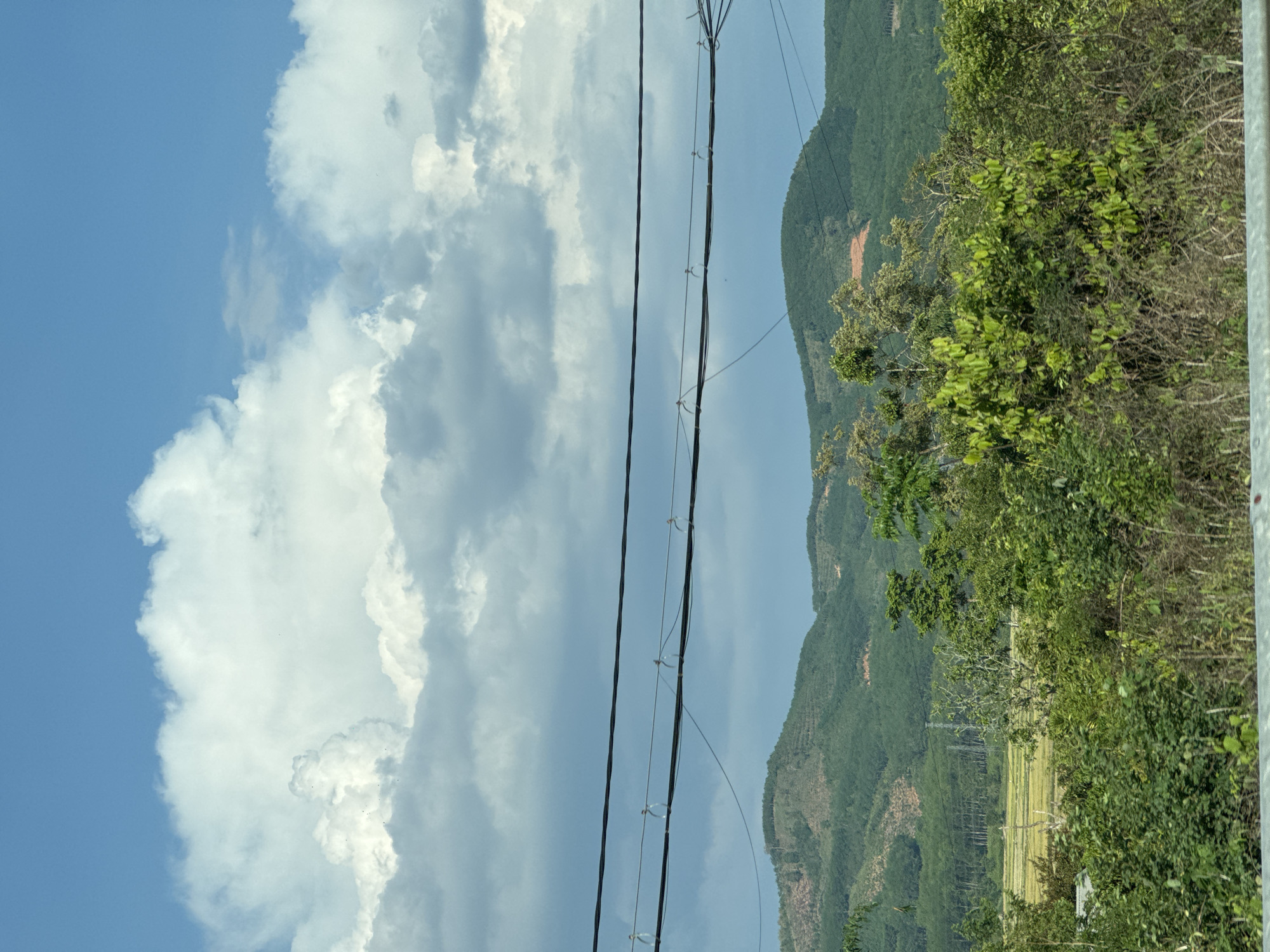 Power lines frame cloudy sky in Đăk La landscape