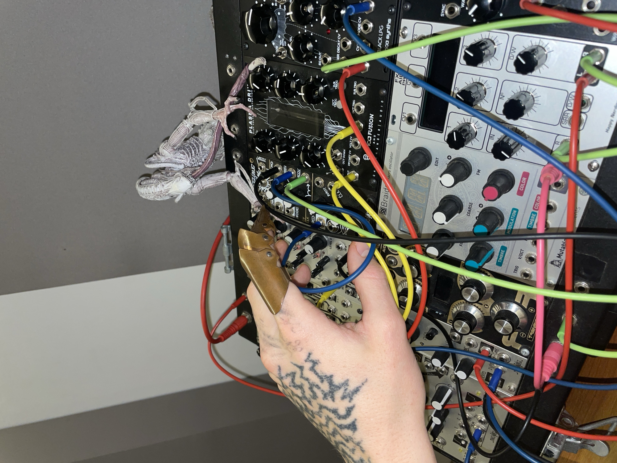 Person operates modular synthesizer with tattooed hand in Argentina