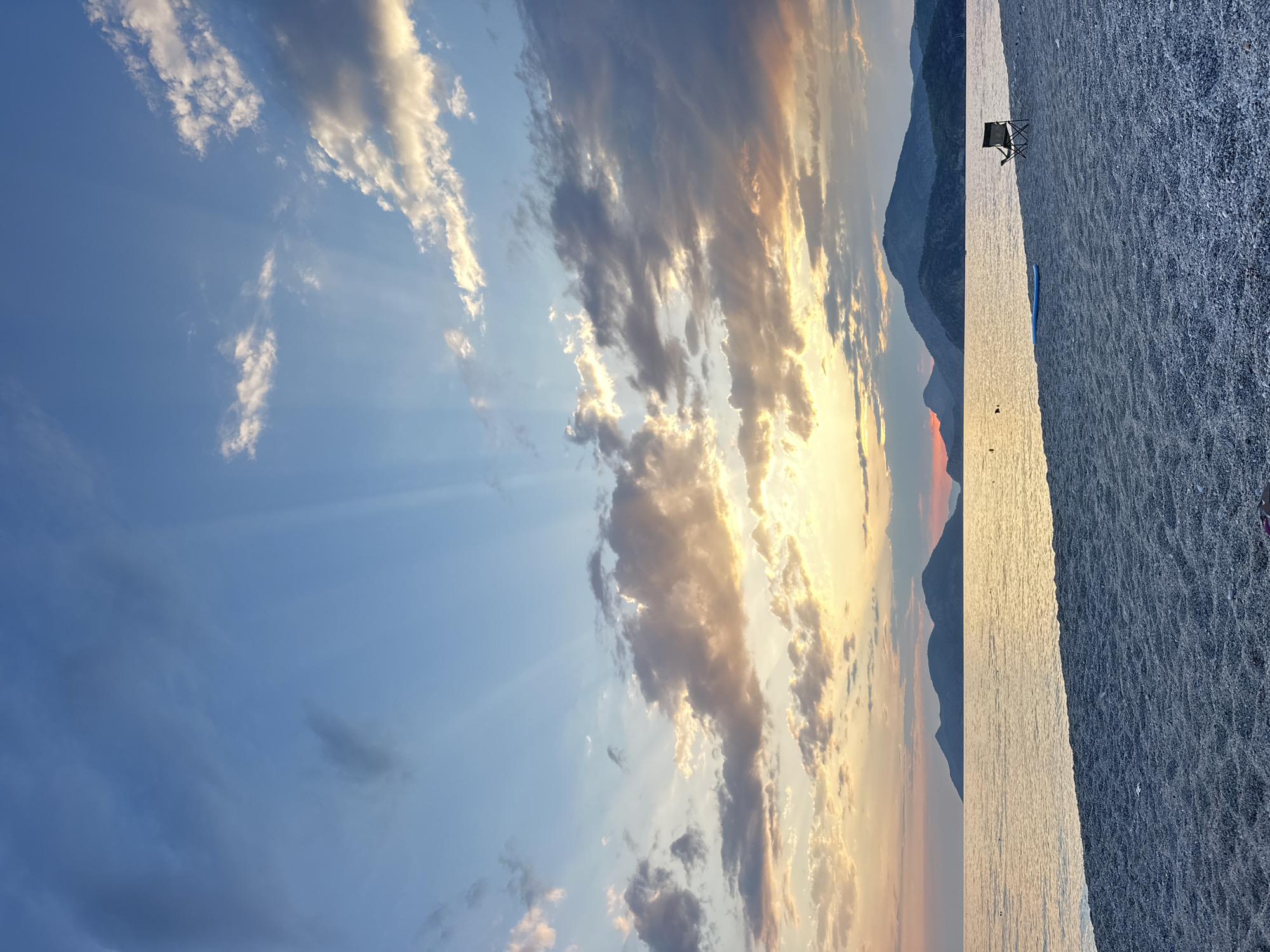 Sunset and paragliders over Fethiye's pebbly coastline