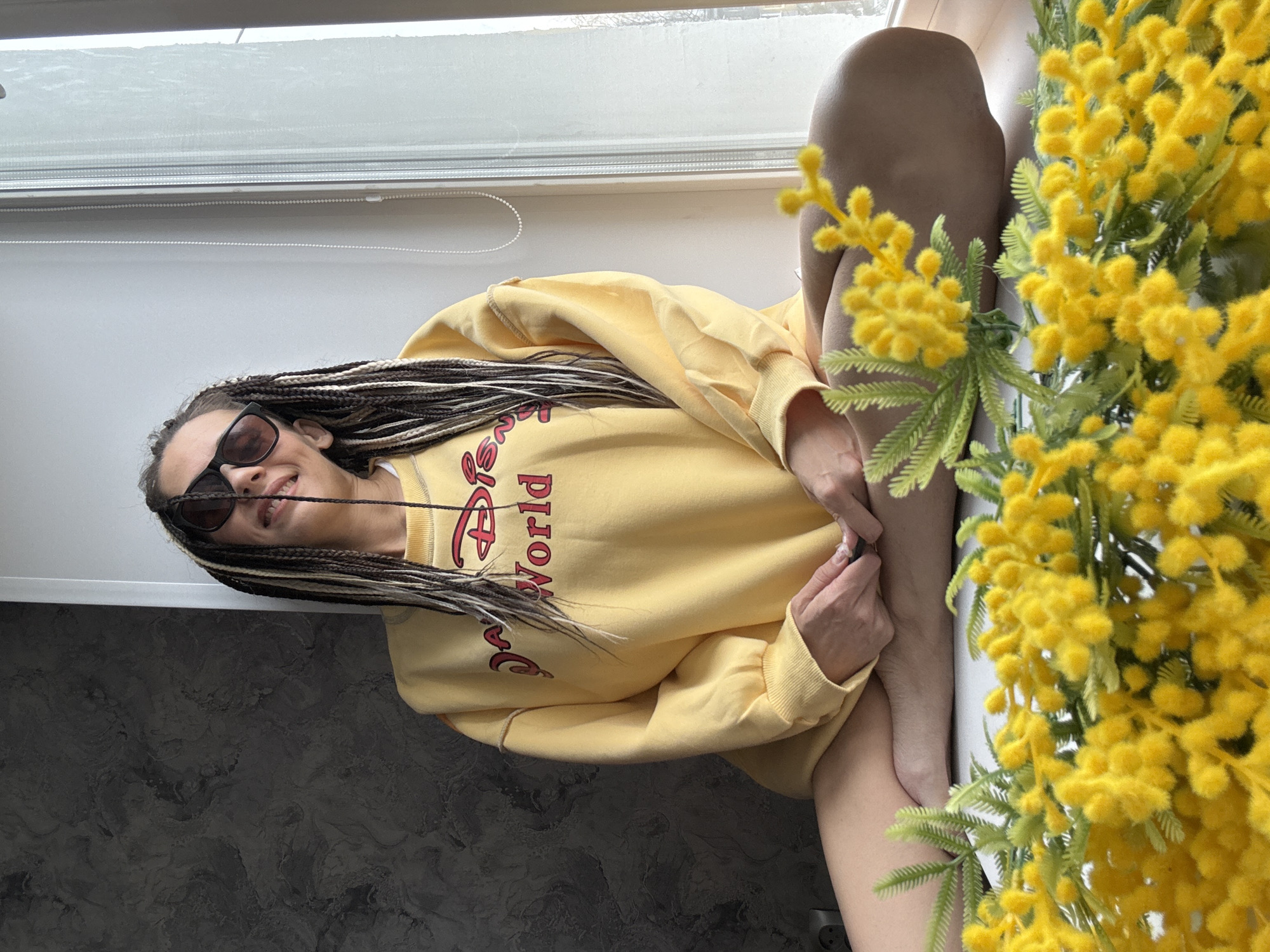 Woman in Disney sweatshirt rests with flowers in Russia