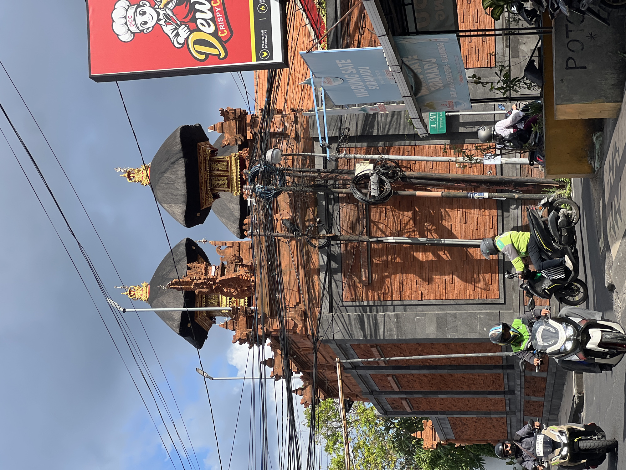 Ornate Balinese temple gate amid Kuta street life