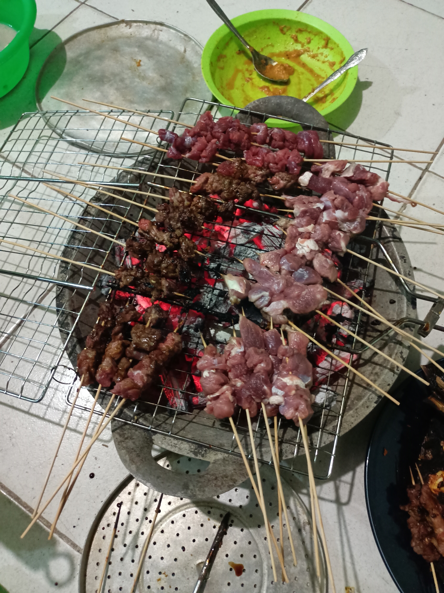 Indoor grilling session prepares fish and satay in Batam